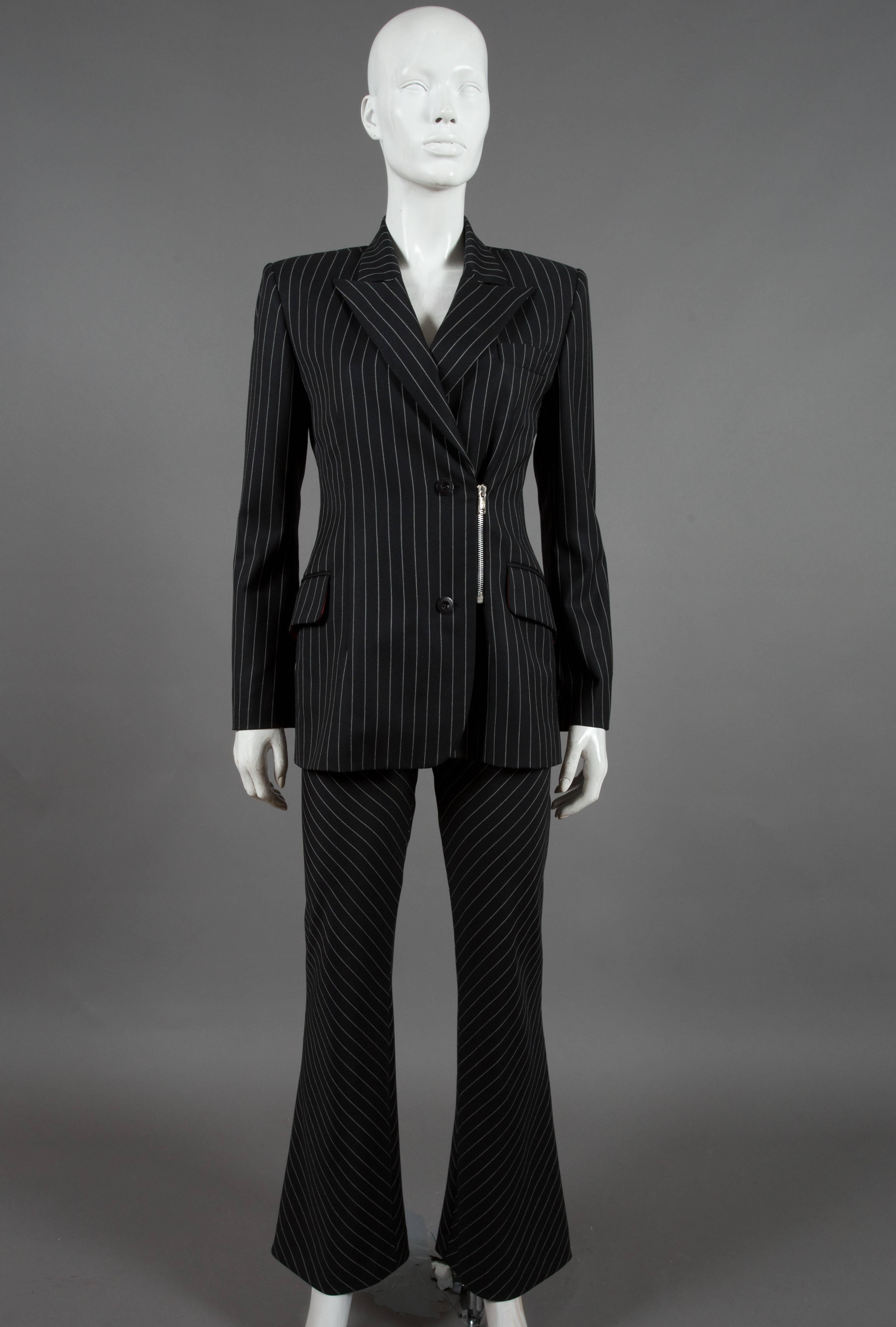 Jean-Charles de Castelbajac black wool pant suit with white pinstripes, circa 1990's. Silver metal zip closure, double breasted, two front flap pockets and flared cropped pants. 

Fr 36