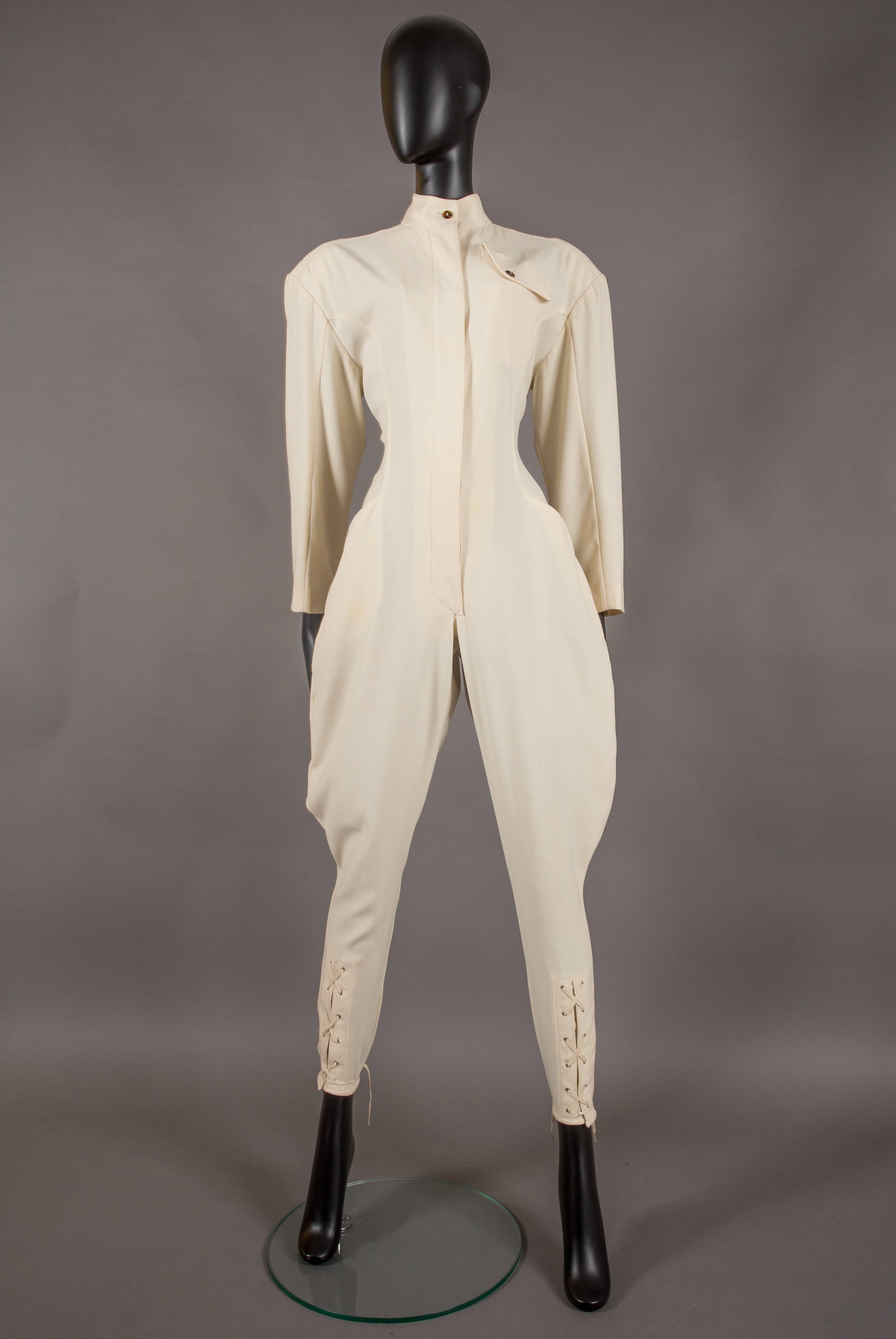 A rare Jean Paul Gaultier ivory jodhpur jumpsuit, circa 1987. 

Exaggerated shoulders with interior shoulder pads, high standing collar, tortoise buttons throughout, two side open pockets, lace-up closures on ankles and wide up sleeves. 


