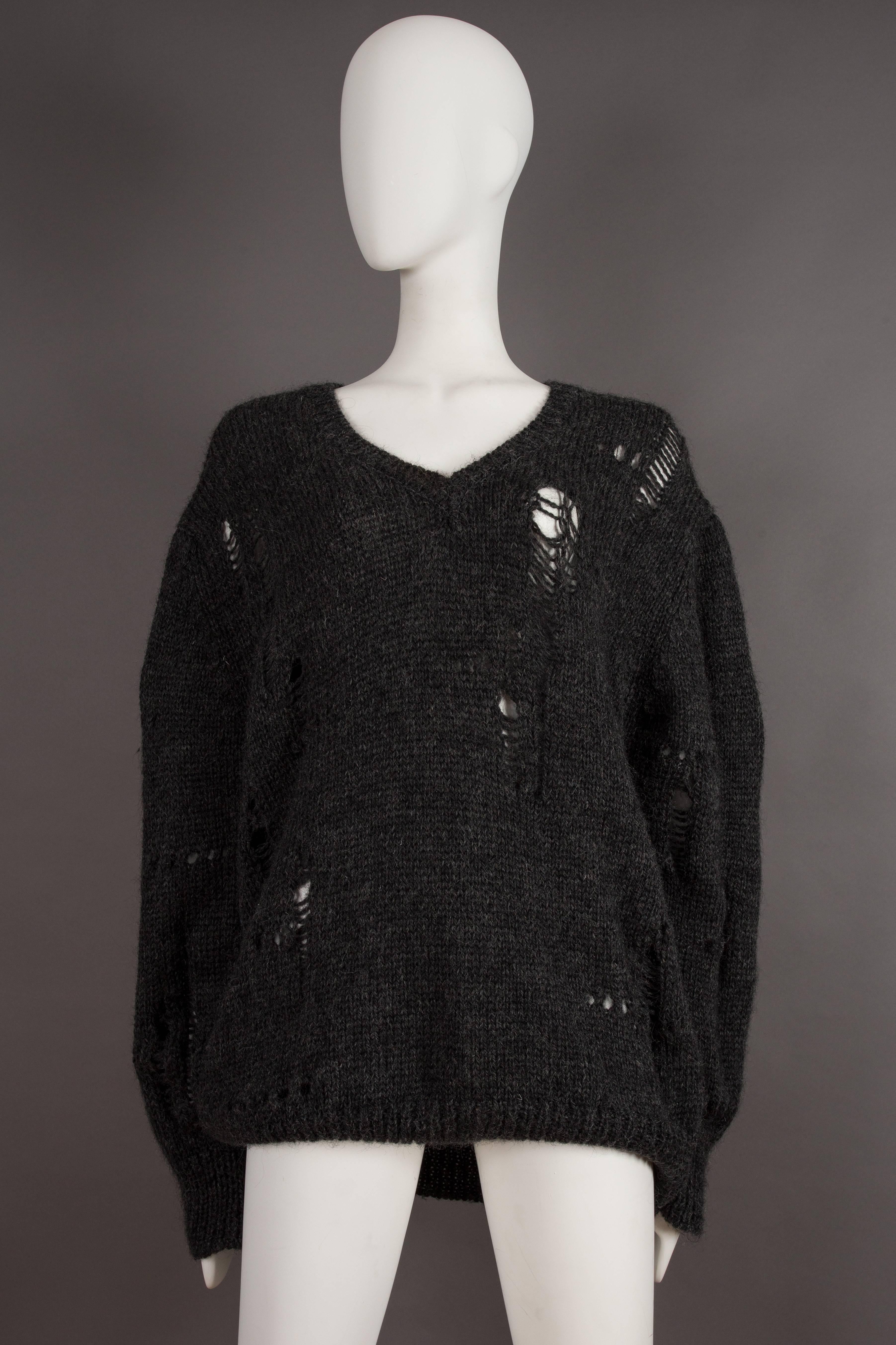 Extremely rare COMME des GARCONS oversized knitted sweater decorated with randomly placed holes, circa 1982. 

This sweater is typical of the predominantly deconstructed and distressed collections produced during the early 1980s by Rei Kawakubo