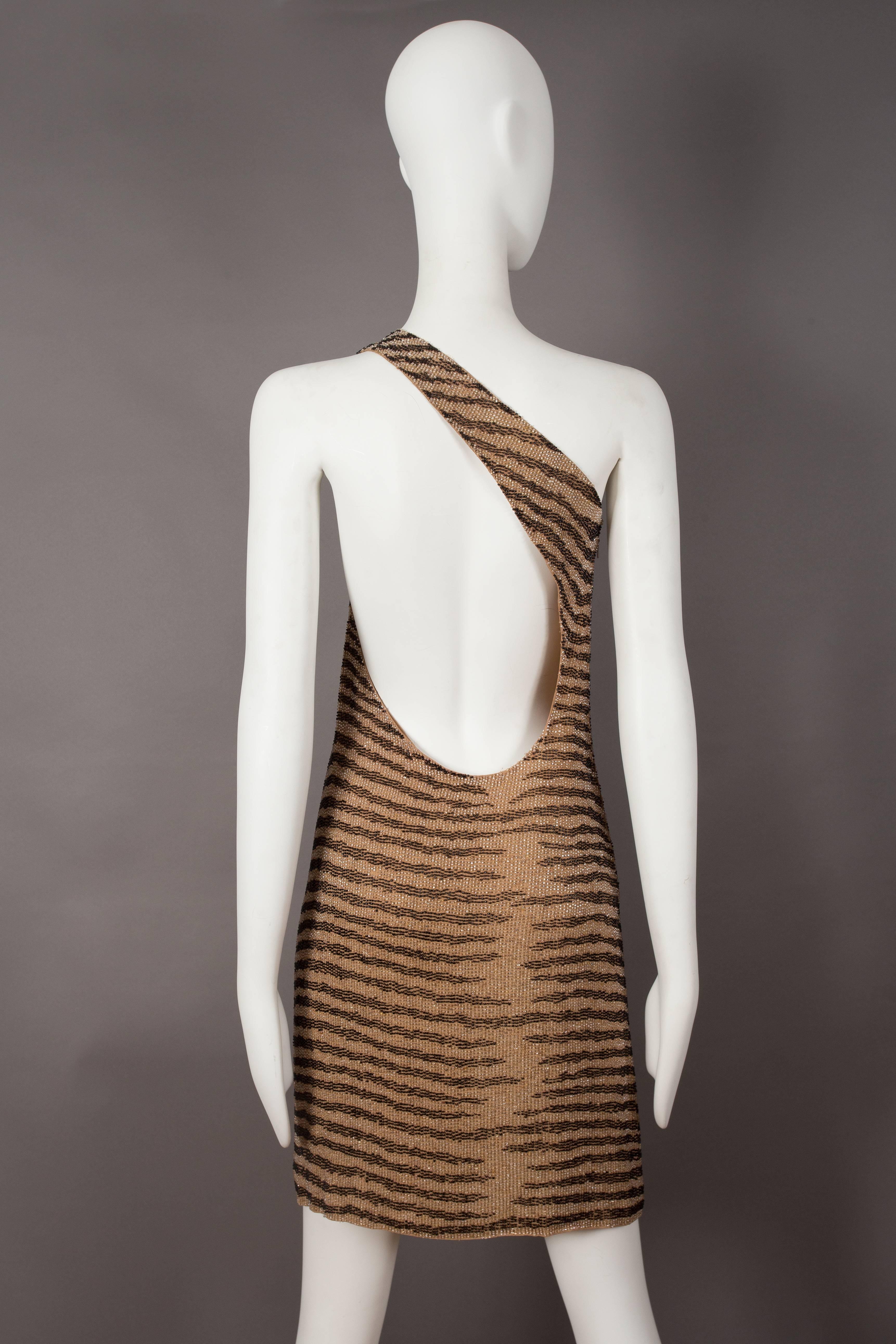 A rare Tom Ford for Gucci evening dress, spring-summer 2000. 

Fully beaded design in zebra print, silk-chiffon lining, invisible zip closure at the side seam and circular cut out at the rear. 