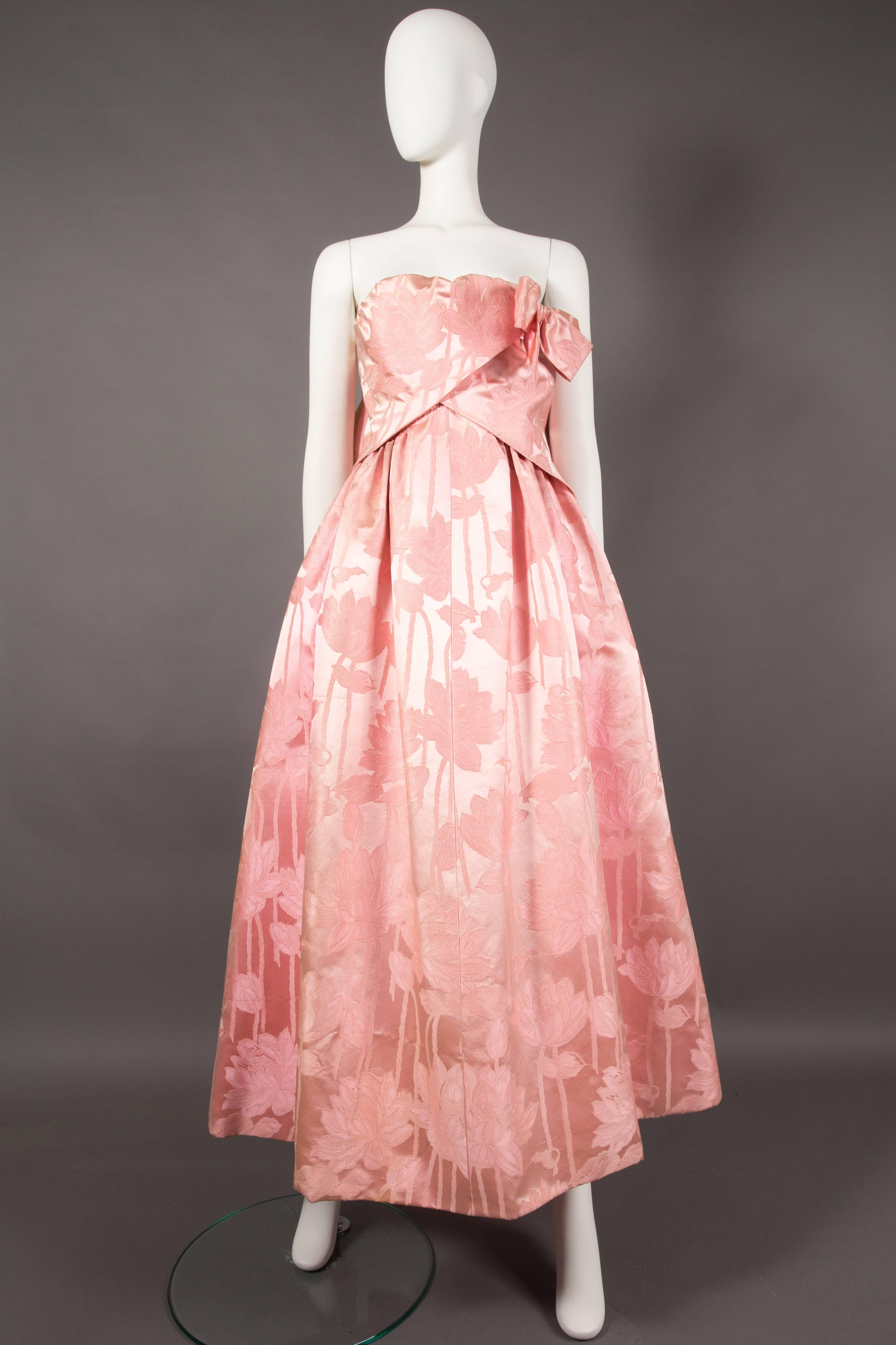 An exquisite and extremely rare haute couture Paul Daunay silk brocade evening gown, circa 1952-57. The dress features a full pleated skirt constructed in a fine silk brocade layered over a structered underskirt. The strapless bust has an internal