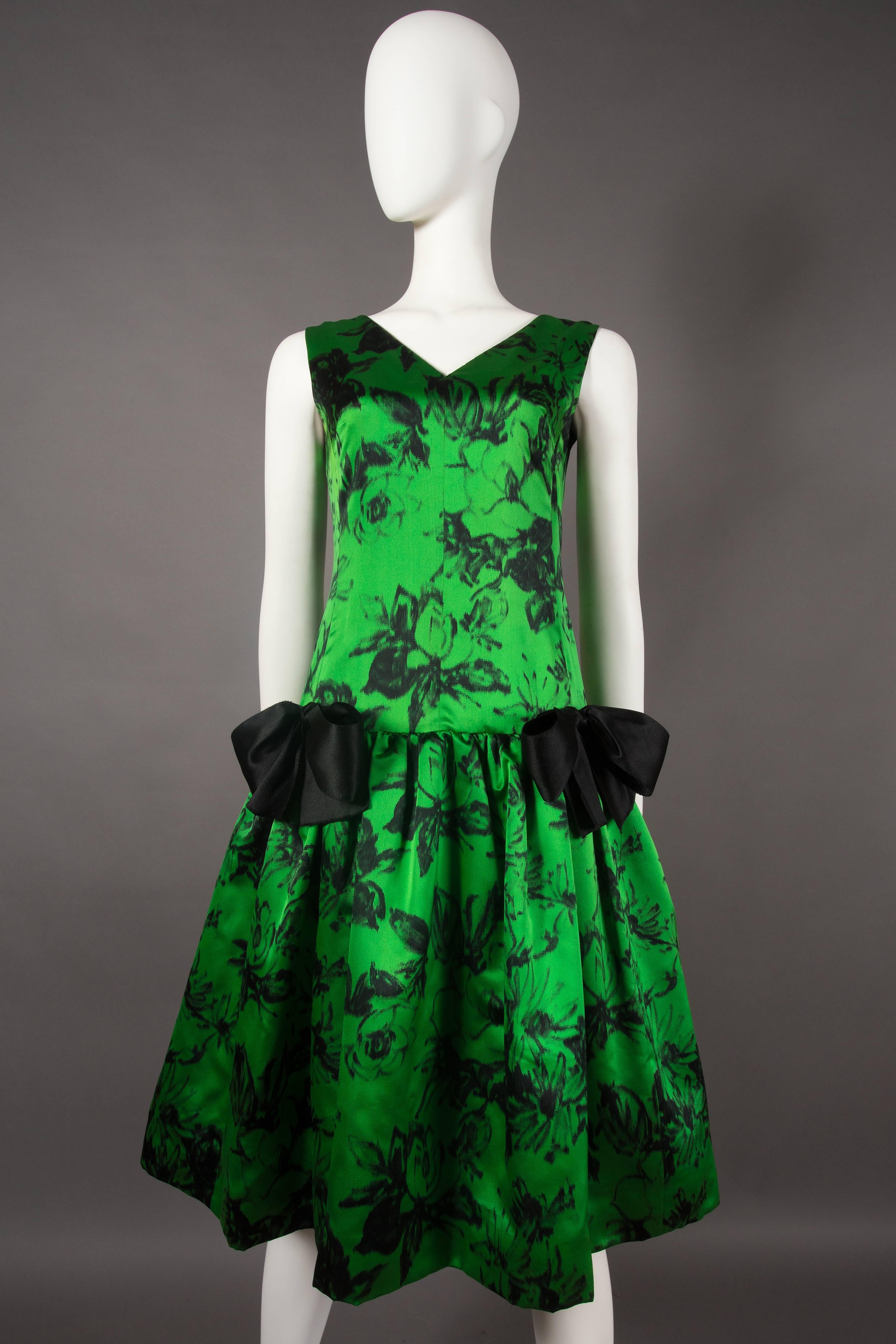 Wir präsentieren ein exquisites und äußerst seltenes Cocktailkleid von Paul Daunay, ein wahrer Schatz aus der Zeit um 1952-57. Dieses raffinierte Kleid aus feinem Seidenstoff mit abstraktem Blumendruck strahlt zeitlose Eleganz und Raffinesse