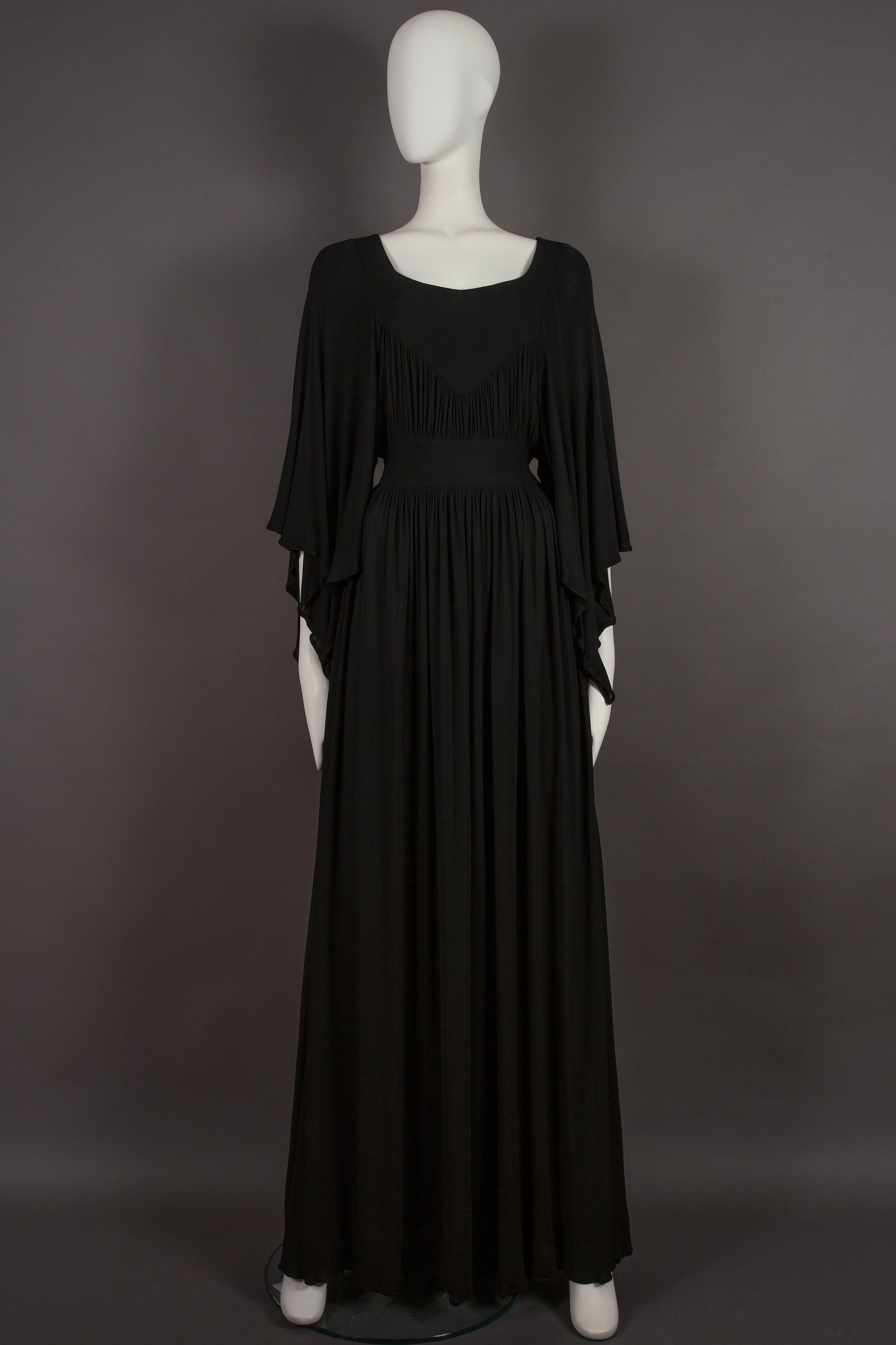 
Presenting an exceptionally rare and exquisite Ossie Clark for Quorum black jersey evening gown, a timeless treasure from the era of circa 1965-68. This gown is a true testament to the artistry of its designers and exudes an aura of elegance and