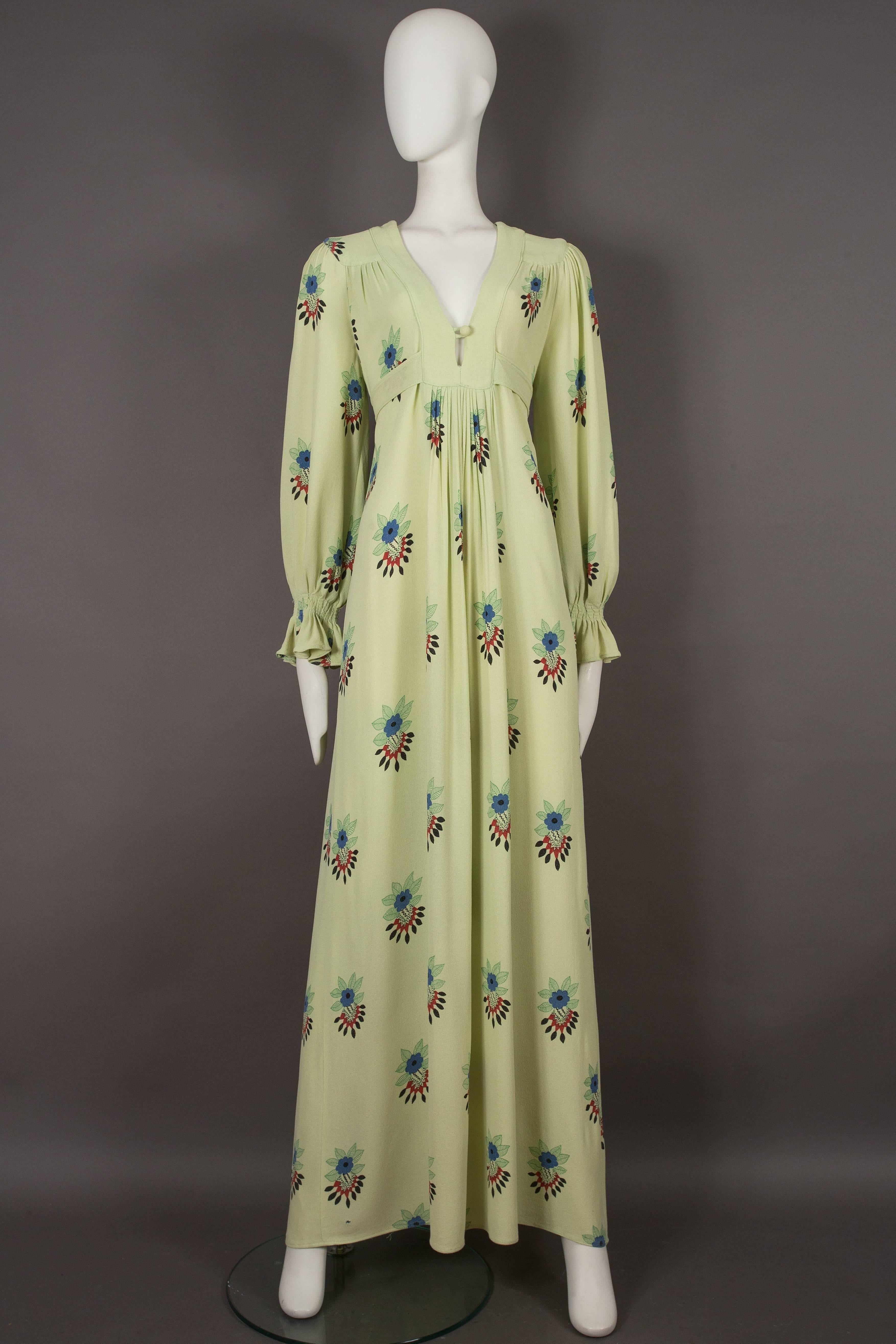 A rare Ossie Clark moss crepe maxi dress, circa 1970s. The dress features one of Celia Birtwell's iconic prints throughout on a lime green base, pleated bishop sleeves with shirred cuffs, waist ties which fasten at the rear and a v-neck with a