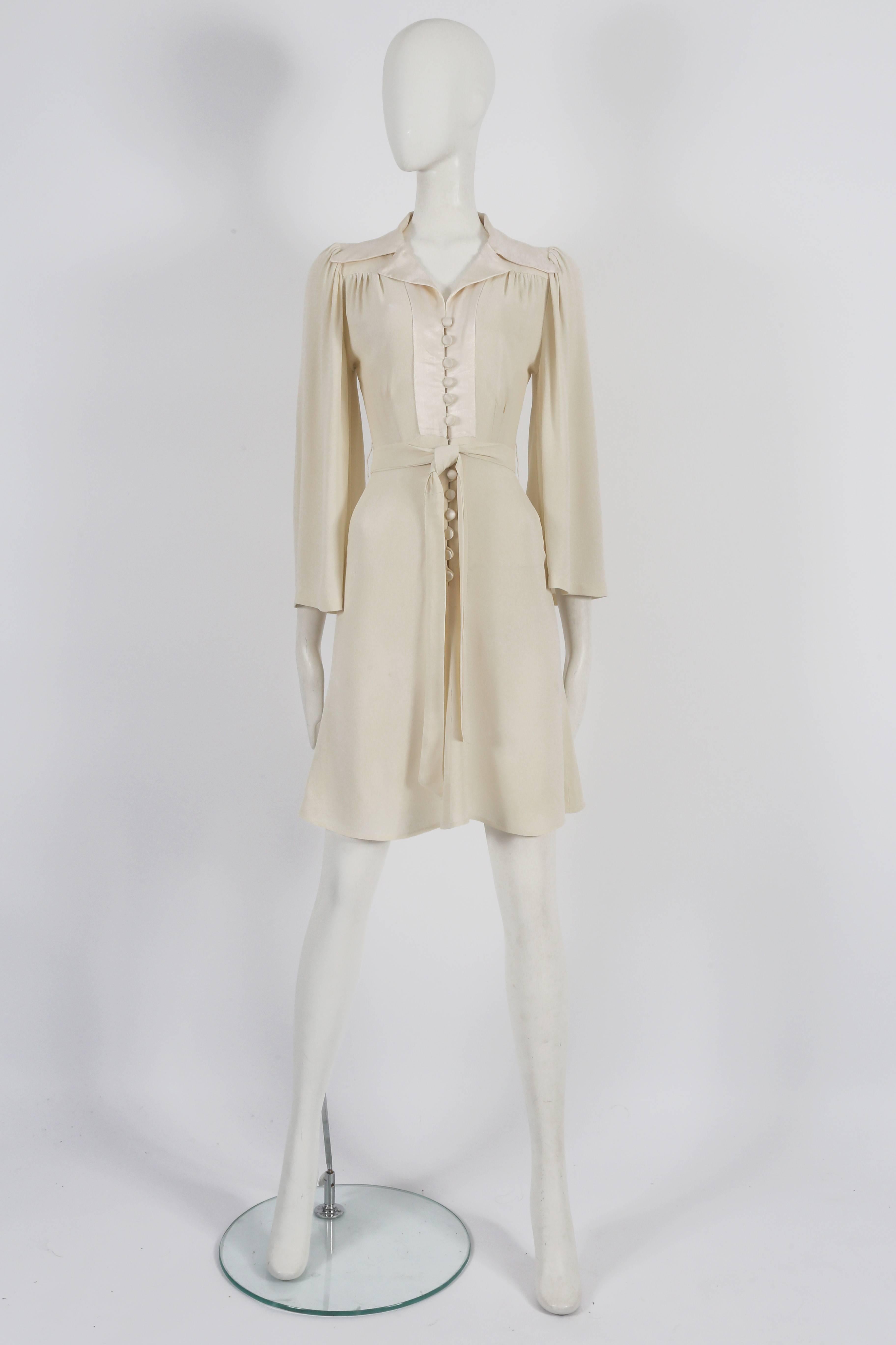 Ossie Clark ivory moss crepe mini dress with satin collar, circa late 1960s. Cropped wide sleeve, fabric button closures and matching waist belt.