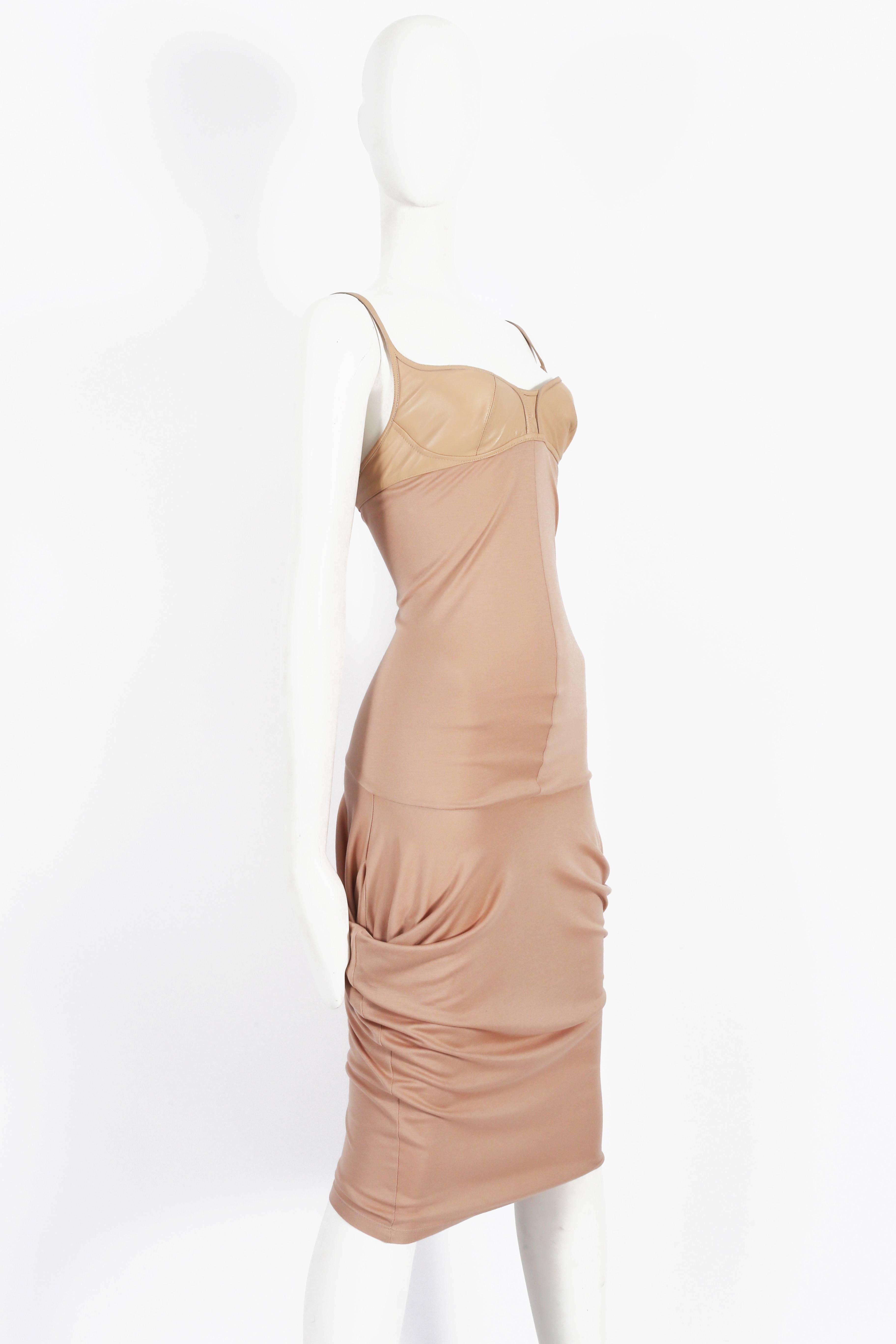Presenting an exquisite Alexander McQueen peach silk jersey evening dress from the spring-summer 2004 collection. This captivating dress exudes opulence and sophistication, showcasing the iconic designer's visionary style.

The dress features an