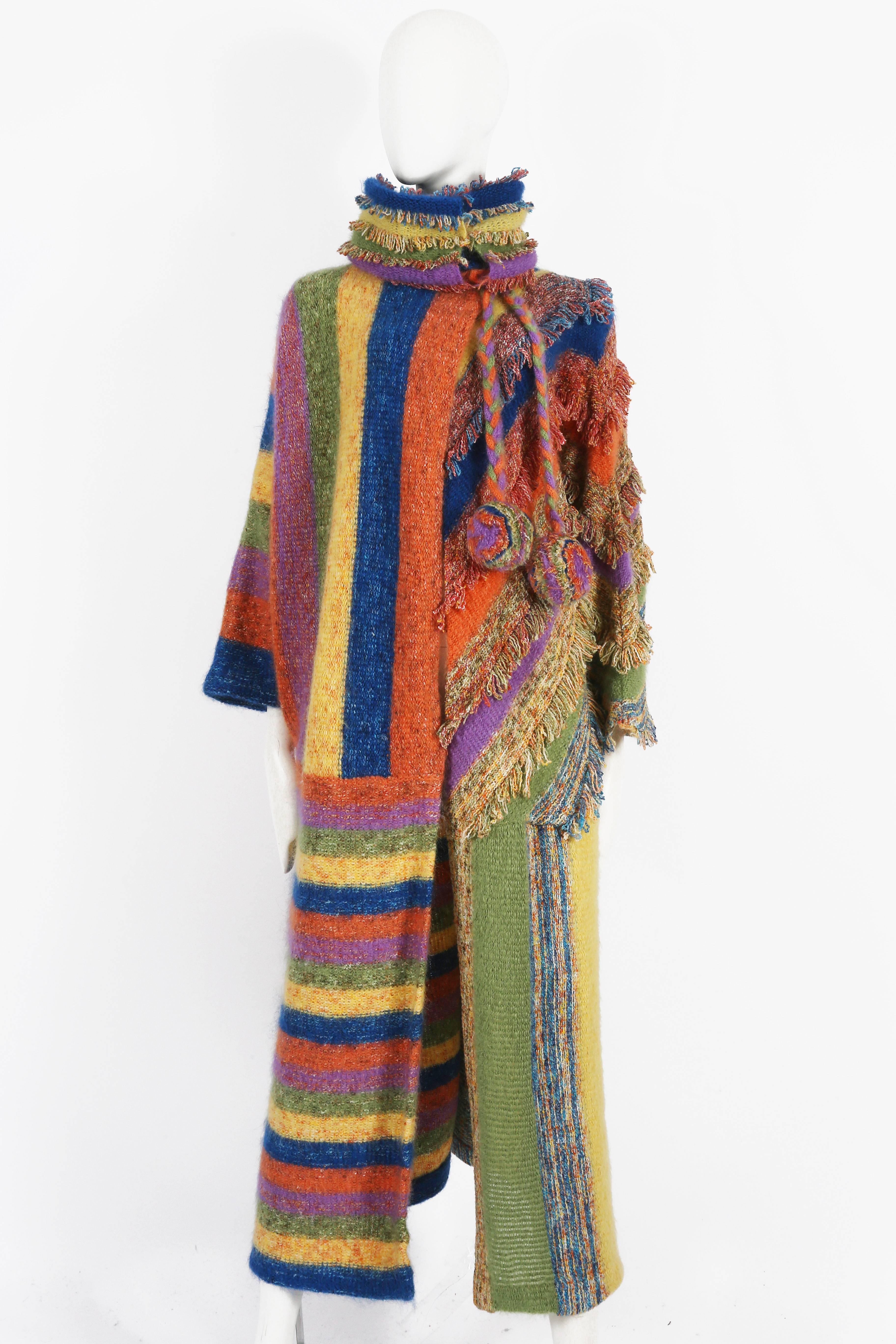 A beautiful and unique 1970s handmade knitted coat in a wonderful multi-colored striped and fringed design. Snap button closures.