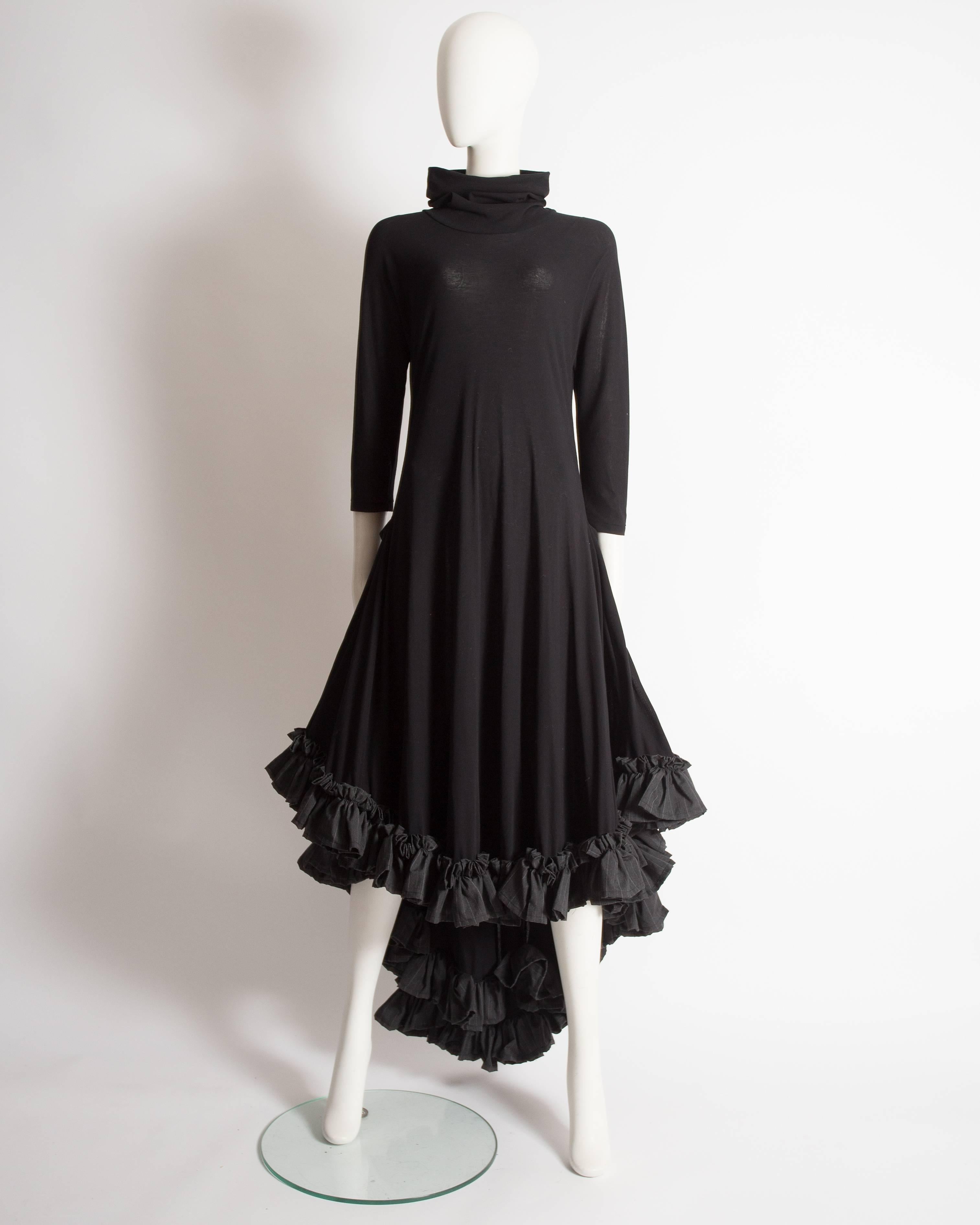 Fine and rare Yohji Yamamoto swing dress constructed in black wool with cowl neck and pinstripe cotton ruffled trim. 

Spring-Summer 1999

Excellent condition