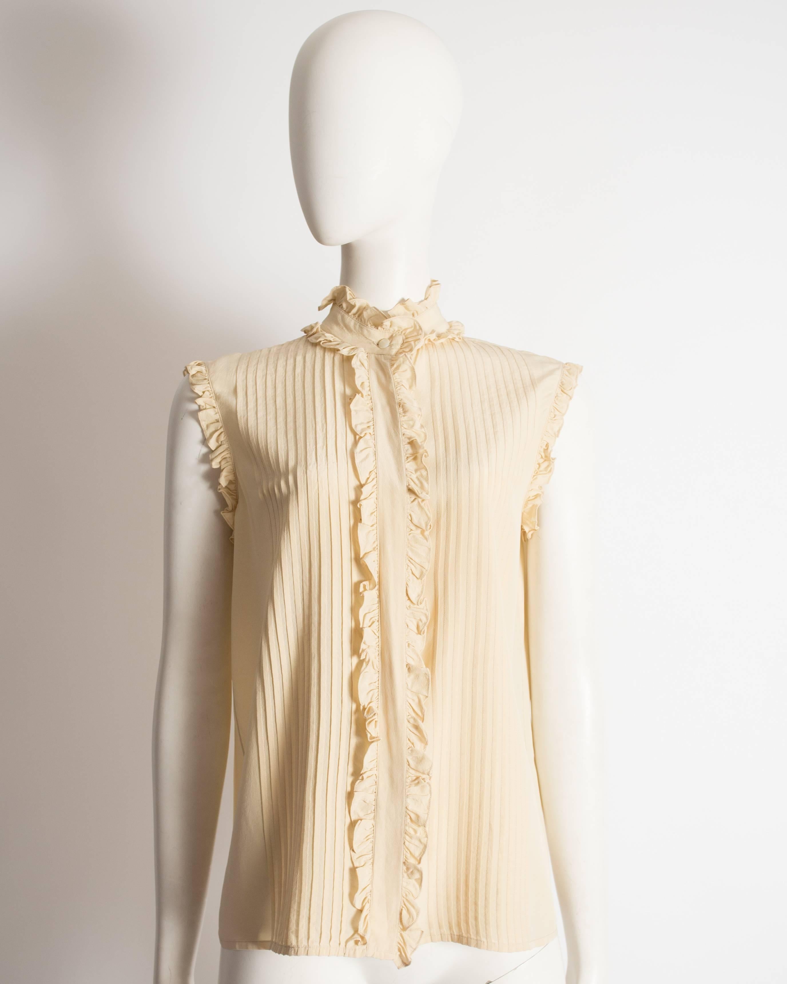 Chanel pintuck blouse constructed in ivory silk with ruffled trim and hidden button closures. 

Circa 1970s