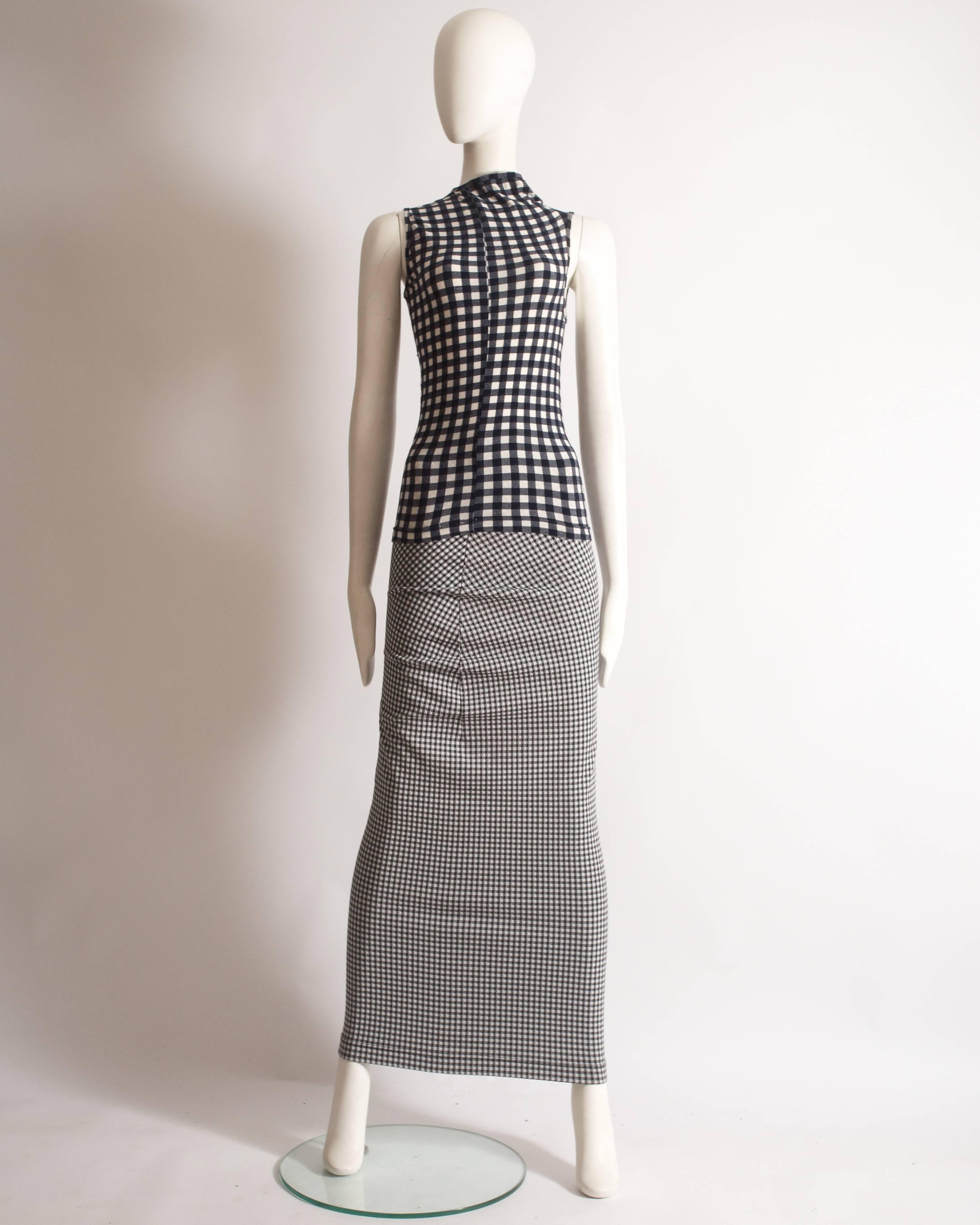 Important and rare Comme des Garcons gingham skirt suit, 'Body Meets Dress, Dress Meets Body' Spring-Summer 1997. The suit features a deconstructed design throughout, dark navy gingham vest and fitted black gingham skirt. 

