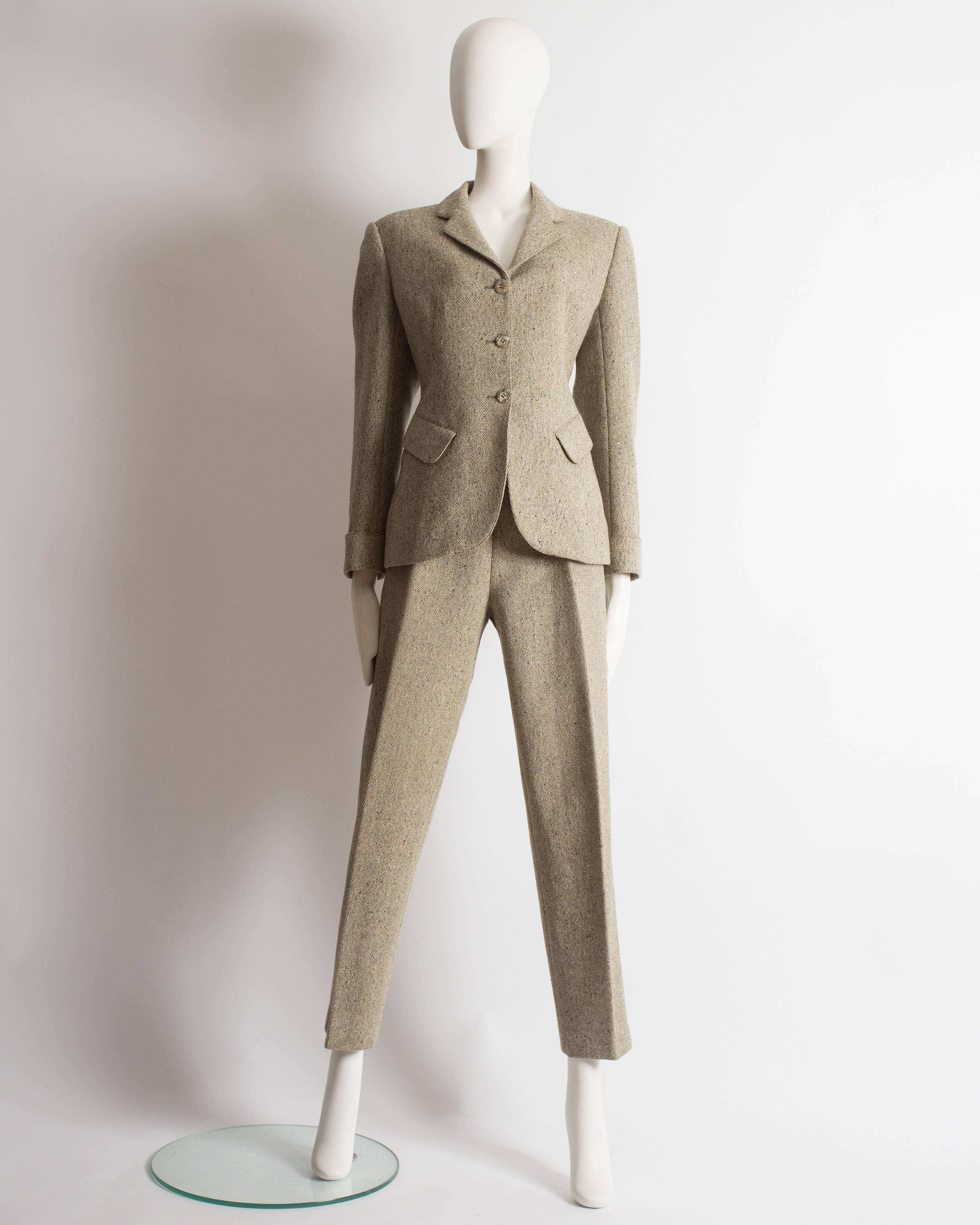 Alaia pant suit constructed in wool tweed, Autumn-Winter 1987. High waisted cigarette pants with center pleats, blazer jacket with three button closure, turnover cuffs, diagonal front flap pockets and silk lining. 
