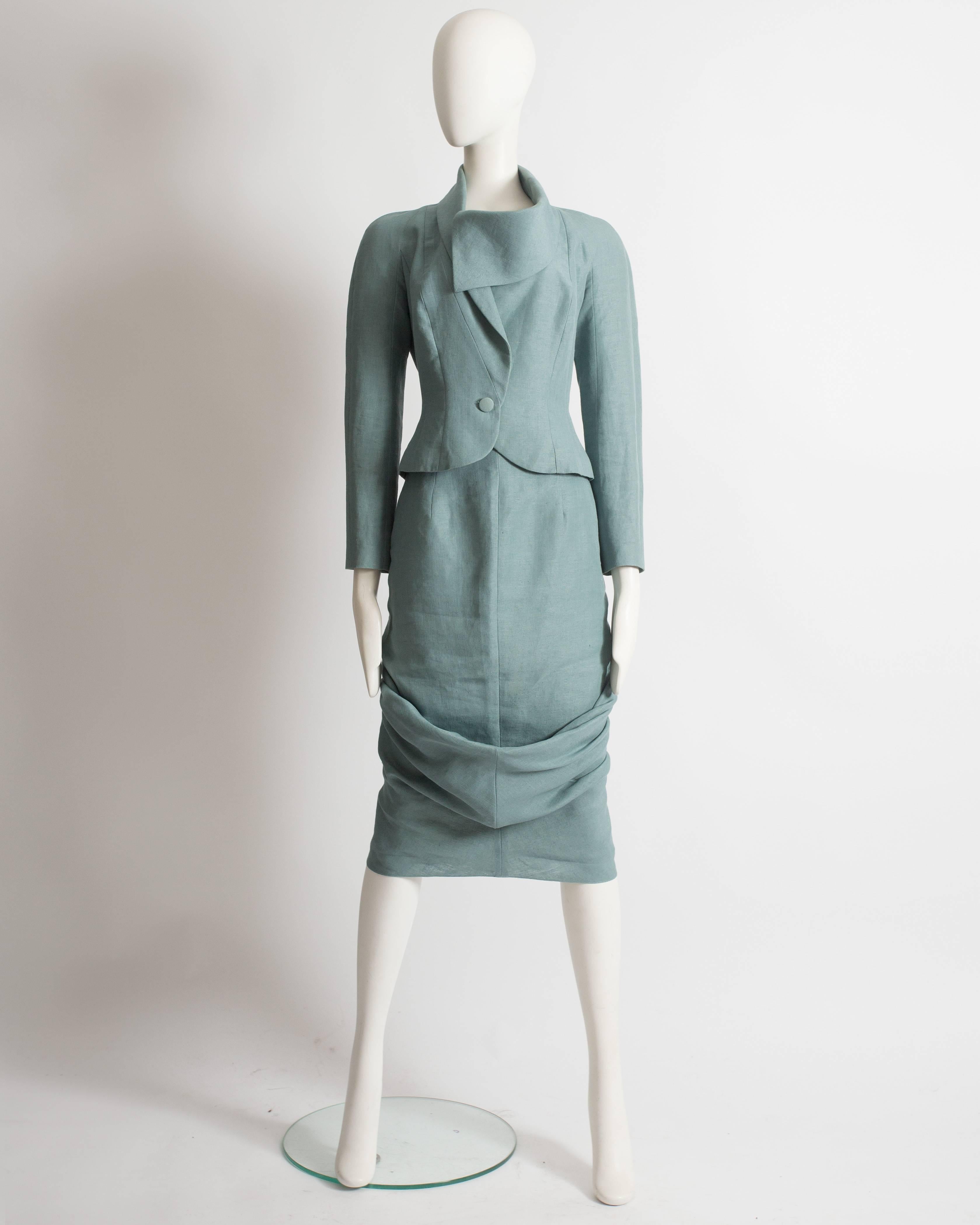 Introducing a captivating John Galliano skirt suit, a true representation of elegance from the spring-summer 1999 collection. This suit showcases the designer's impeccable tailoring and innovative design.

Constructed in a stunning teal-colored