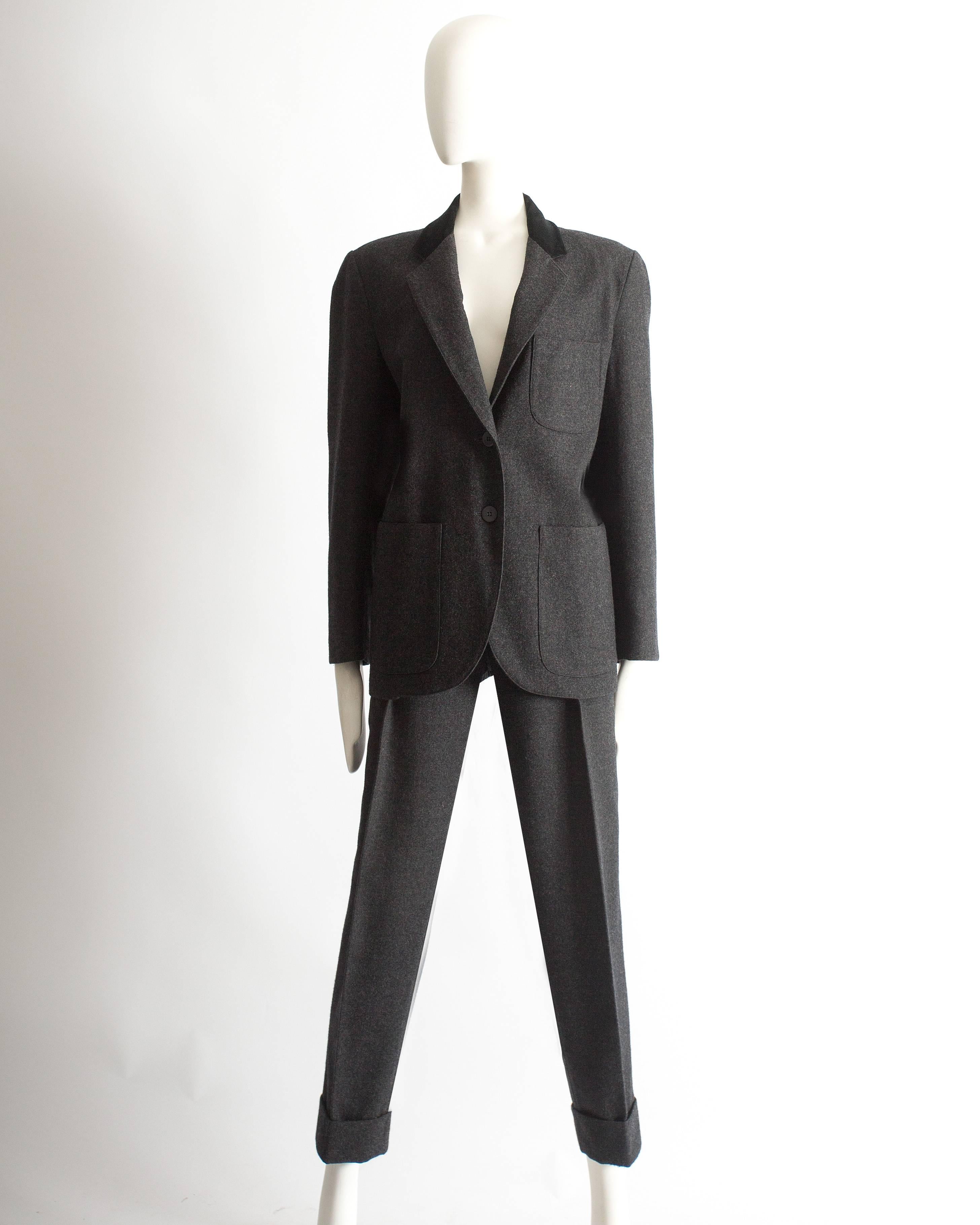 Presenting an exquisite Azzedine Alaia charcoal grey molten wool trouser suit, a true masterpiece from the autumn-winter 1987 collection. This suit exemplifies the designer's impeccable tailoring and timeless style.

The boxy cut jacket, with its