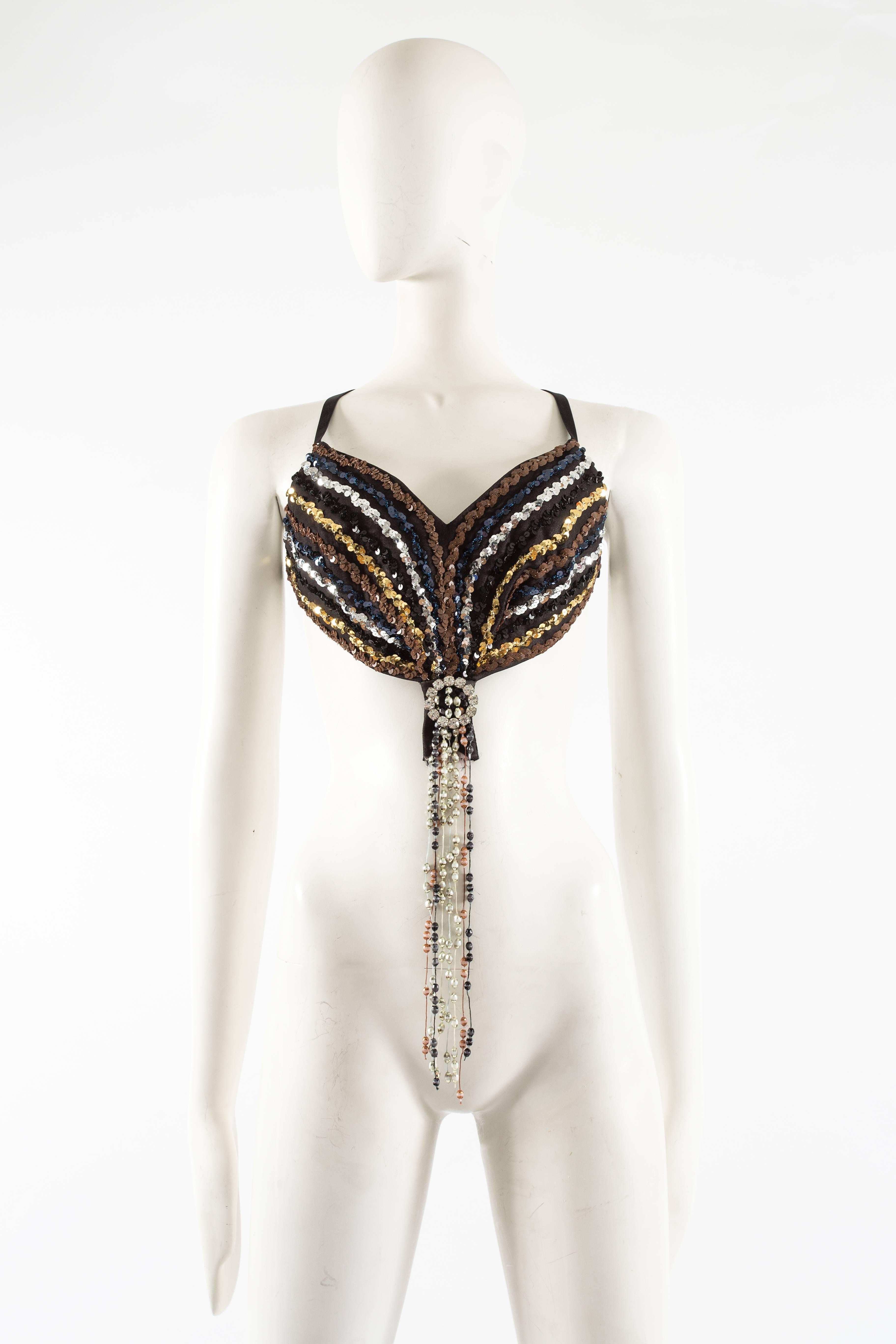 Introducing an exquisite archival piece from Martin Margiela's Autumn-Winter 2006 collection, the Sequin Bralette, a true gem that epitomizes the brand's unique and daring approach to fashion.

Adorned with a circular rhinestone brooch, this