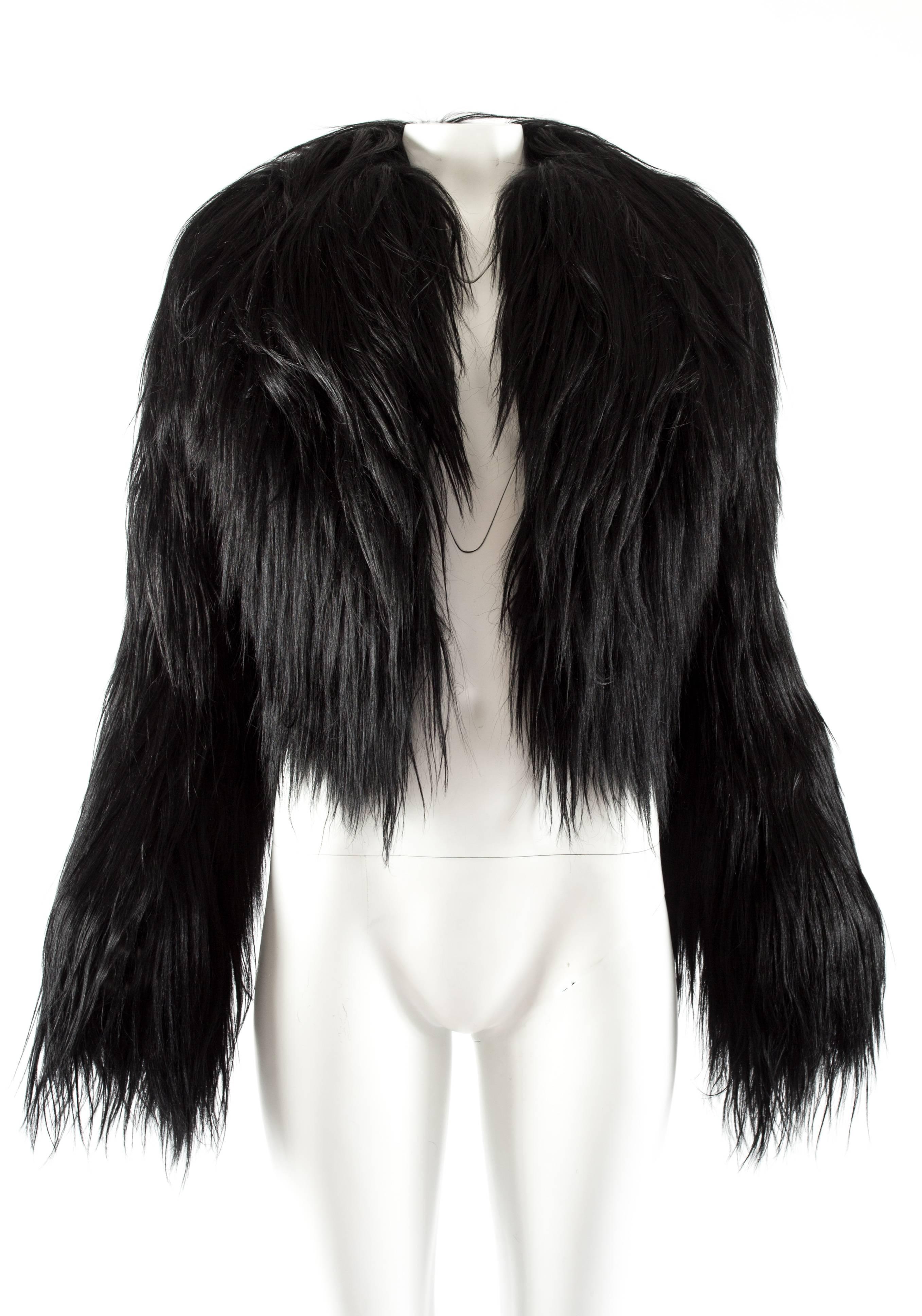 Voici la veste en poils de chèvre noirs Azzedine Alaia, une pièce luxueuse et exquise qui illustre la maîtrise du créateur dans la création d'une mode intemporelle et sophistiquée.

Confectionnée dans un somptueux poil de chèvre d'un noir éclatant,