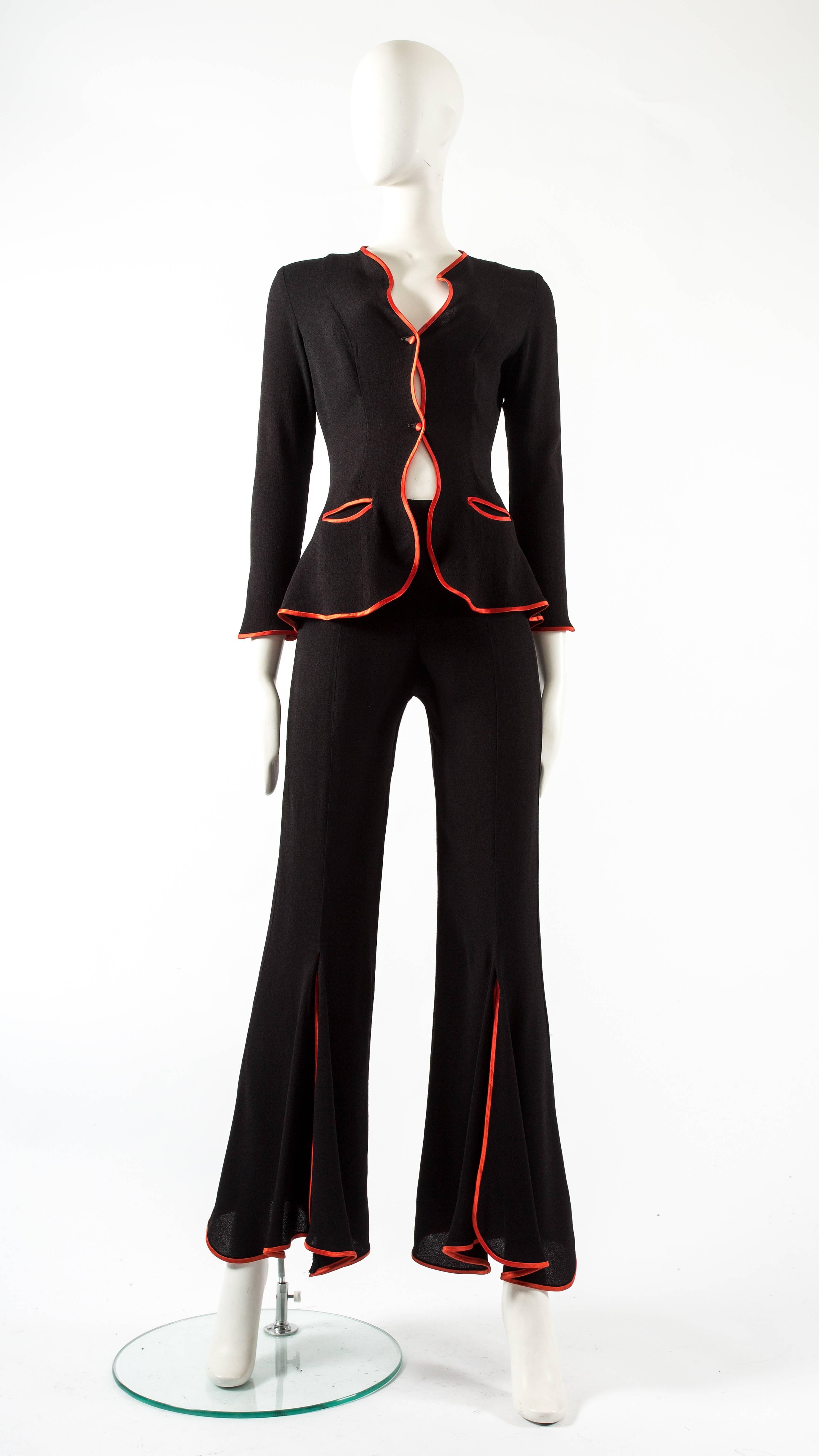 Ossie Clark 1970 black moss crepe 'Judy' trouser suit, with undulating borders piped in red satin.