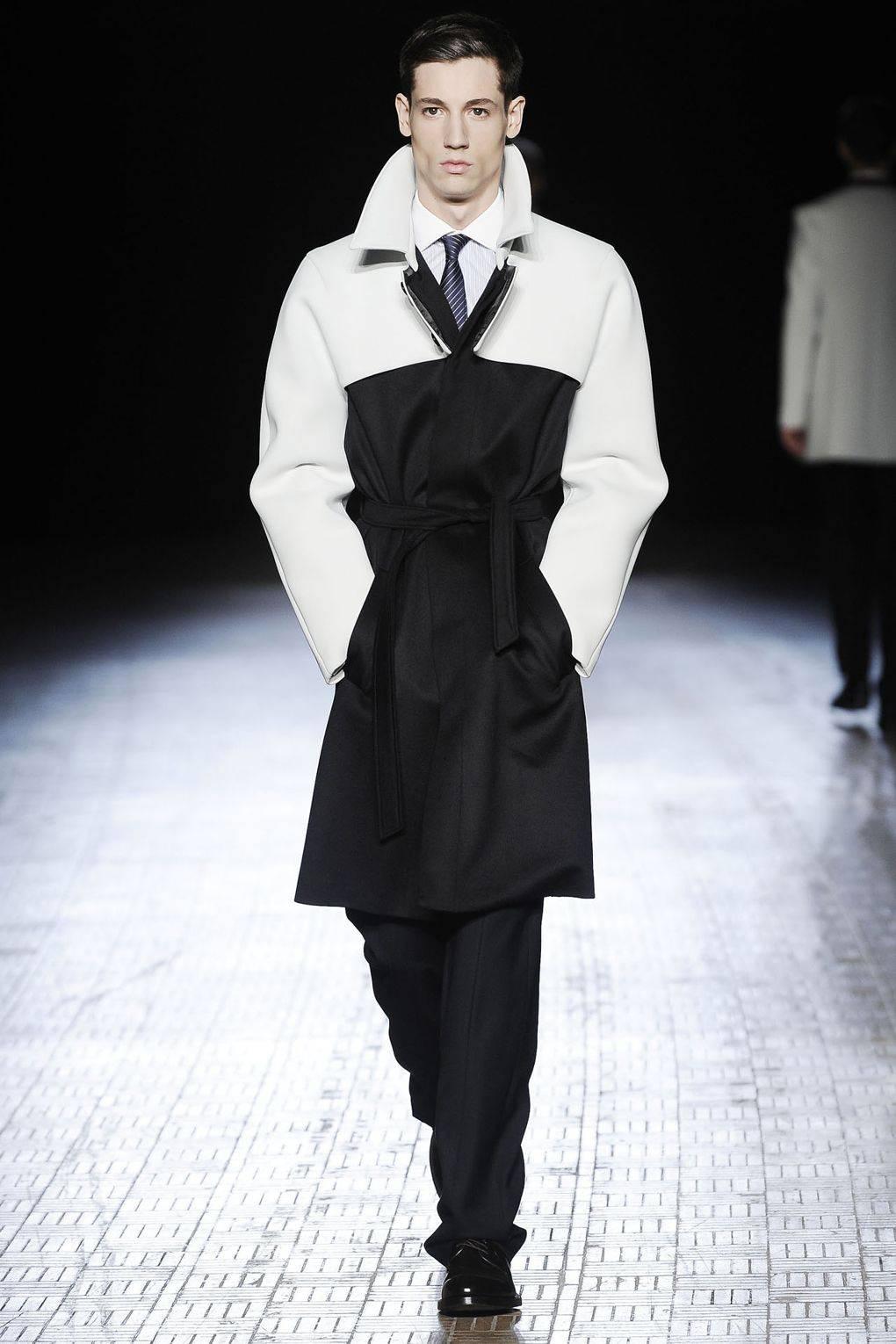 Introducing the Raf Simons Autumn-Winter 2009 black wool men's coat, a striking and innovative piece that exemplifies the designer's bold and visionary approach to menswear.

Crafted from luxurious black wool, this coat exudes elegance and