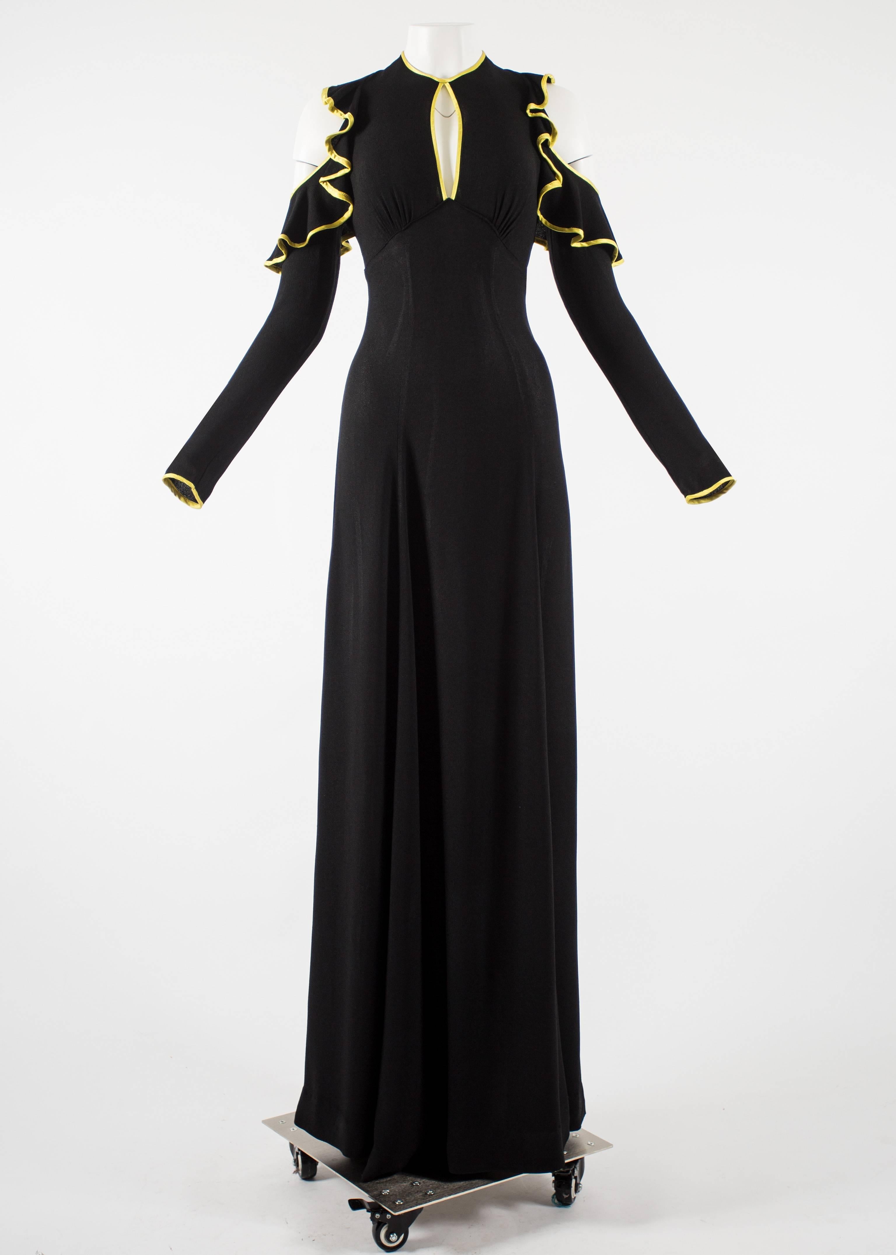 Ossie Clark 1968 black moss crepe  evening dress. Cold shoulder design with ruffles, yellow satin trim throughout, peek-a-boo cleavage, open back, bow fastening and metal zip closure on waist.

