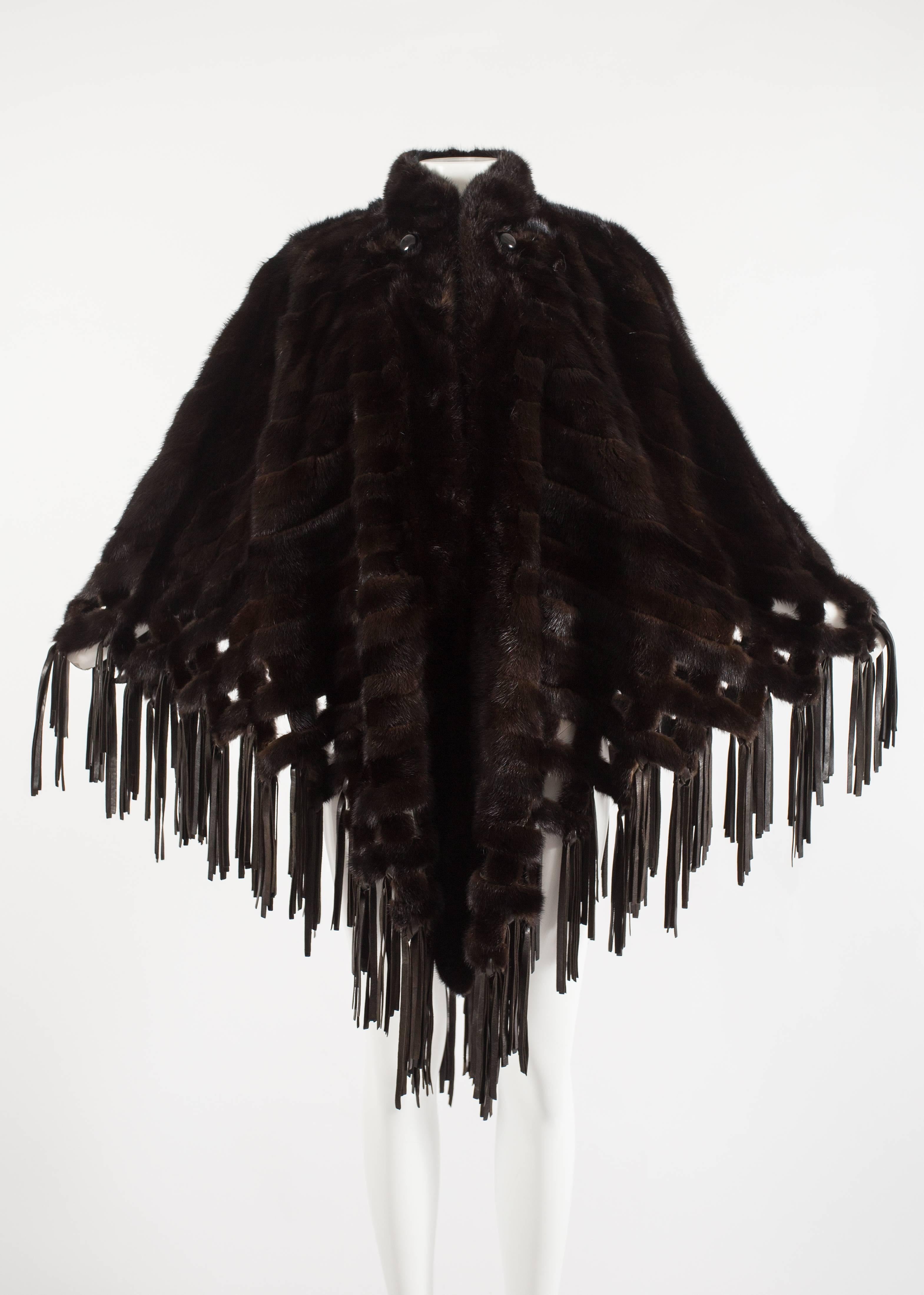 Entrez dans le luxe avec cette exquise cape en vison marron Christian Dior by Marc Bohan, datant des années 1970. Cette pièce opulente arbore des pompons en cuir d'agneau et des fermetures auto-agrippantes, ornées de deux gros boutons pour une