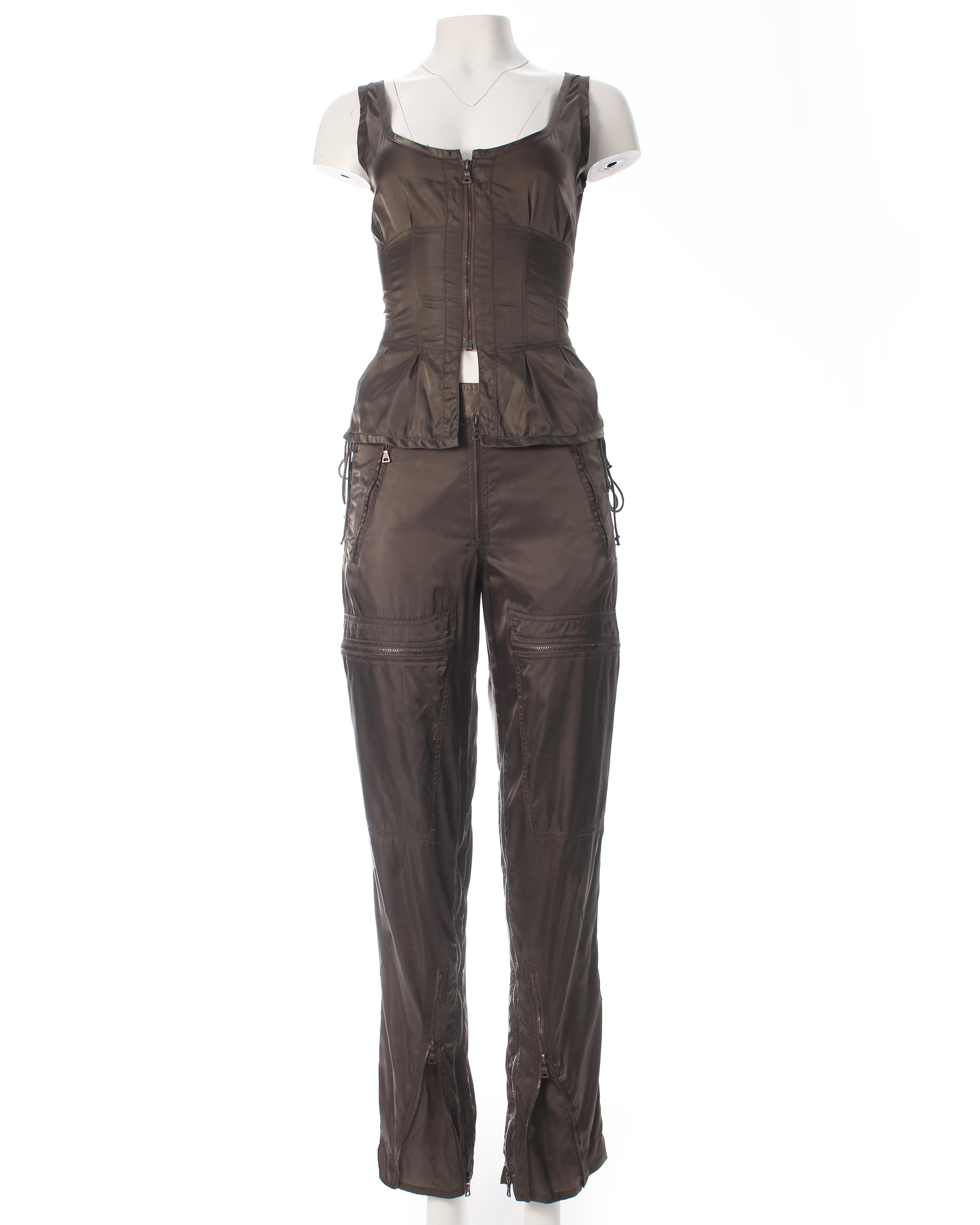 - Vest with zip down center front and lace up fastening at back 
- Cargo pants with multiple pockets and zip fastenings to adjust shape and style 

ca. 1999