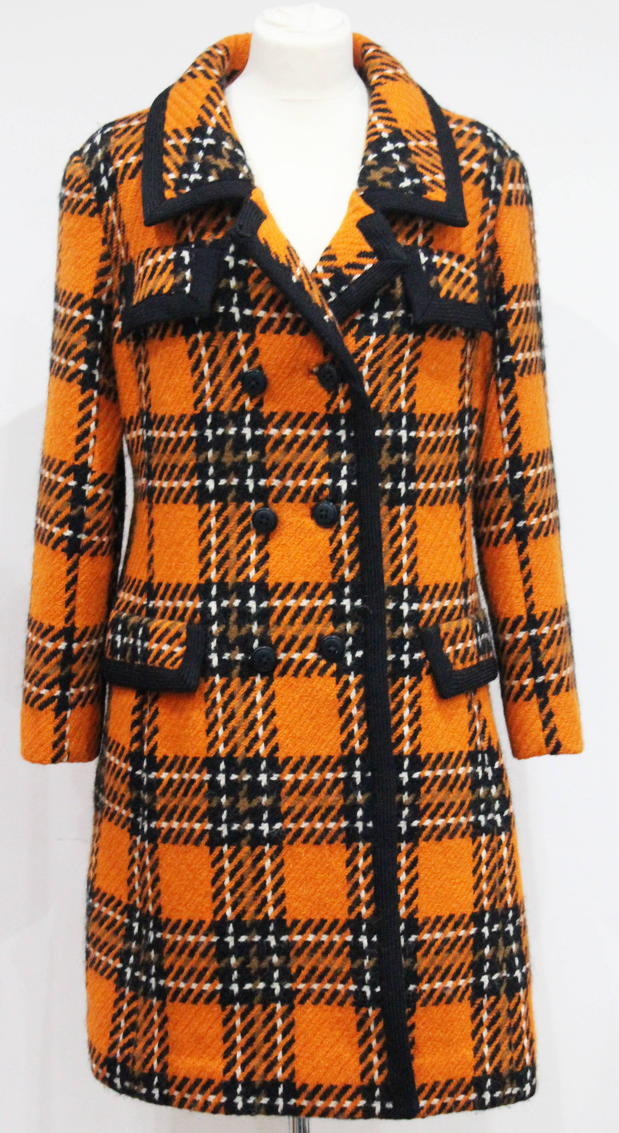 An exceptional english tweed coat by Royal Dressmaker Hardy Amies. The coat is in a vibrant and classic 1960s colour palette with orange, black and white in a fine woollen English tweed. 

Size: Medium - Large / Approx. UK 14 / Fr 42 
Shoulder to