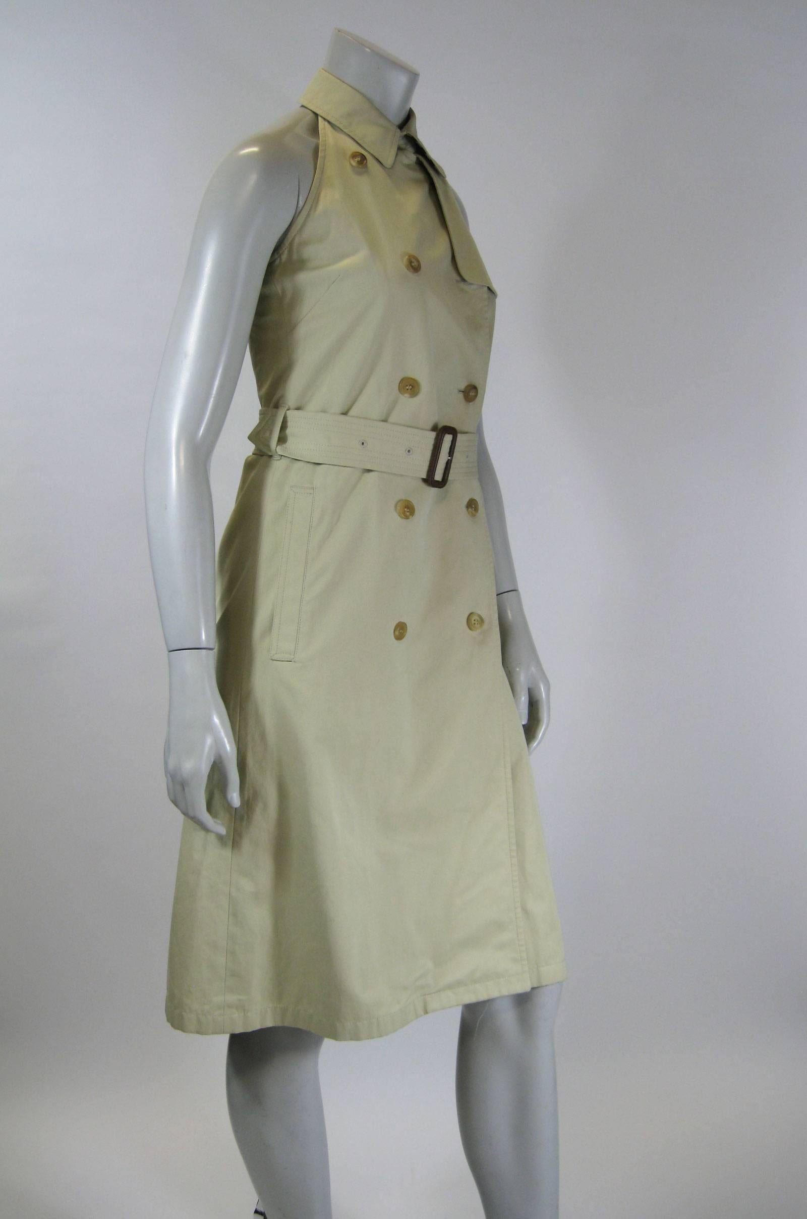 Burberry double breasted trench coat style dress
Halter style top with open back.
Fold over collar with trademark Burberry plaid lining.
Plaid lining inside dress.
Self belt.
Back kick pleat.
Tagged a size US 4.

Bust: 32