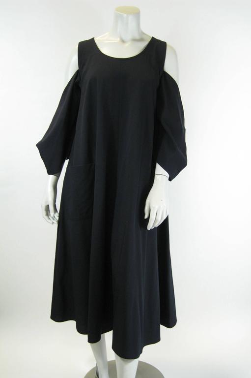 Dark navy blue Yohji Yamamoto dress
Loose a-line with stunning cut out shoulder kimono style sleeves.
Large patch pockets.
Refined wool/nylon blend.
Tagged a size Small.

Bust: 38