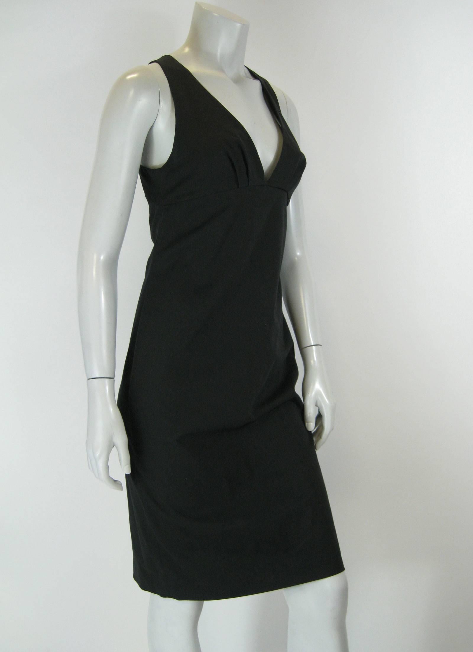 Black Gucci fitted dress.
Empire waist with plunging neckline.
Wide straps that twist in the back.
Concealed side zipper.
Stretchy cotton for snug fit.
Back vent on skirt.
Tagged a size 42.

Bust: 34