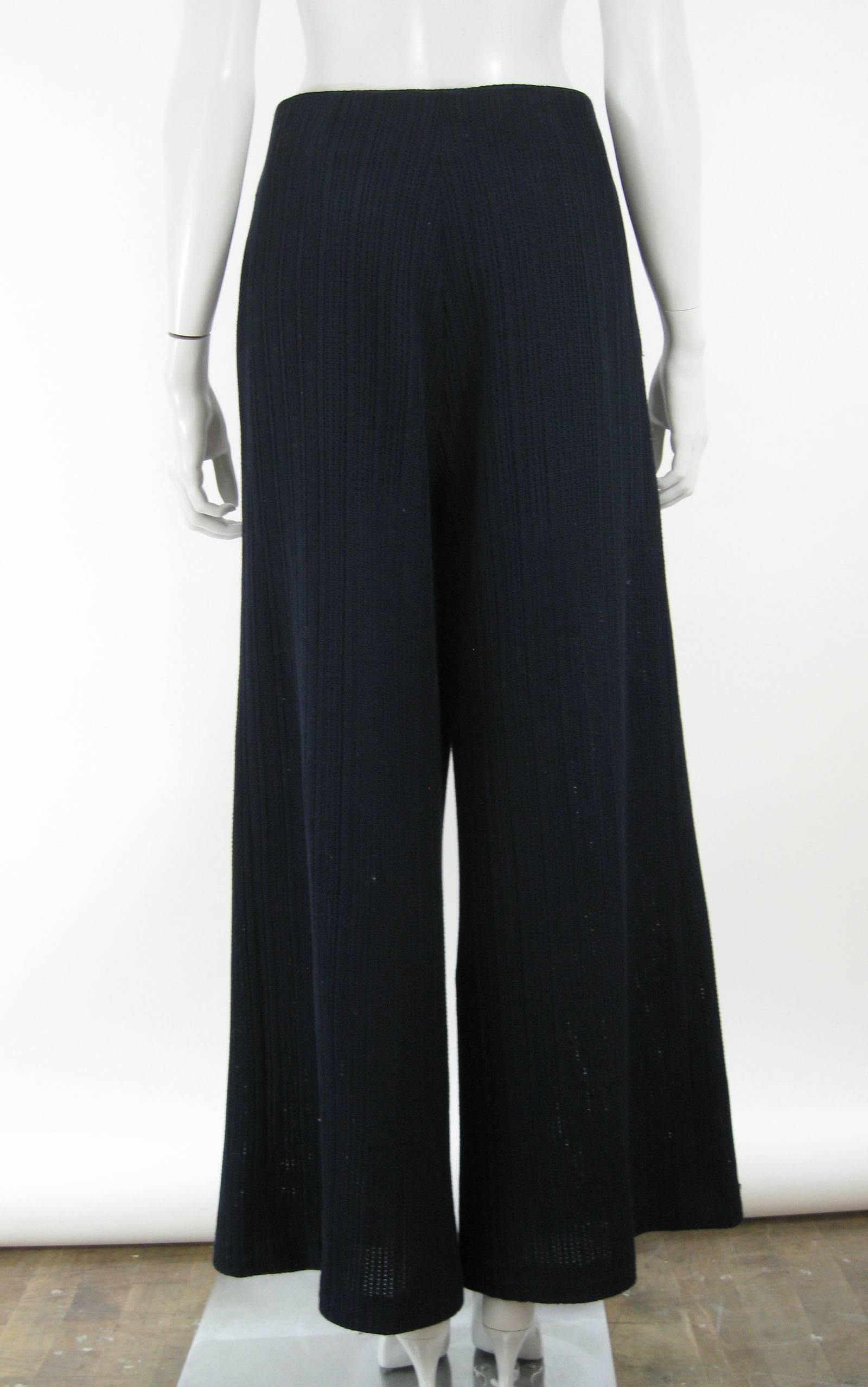 Chanel wide leg pants.
Dark navy blue.
Textured open weave knit fabric.
Inverted pleat detail front hip.
Side zipper.
Decorative Chanel button on hop.
Partially lined.
Side pockets.
Tagged a size 48. 

