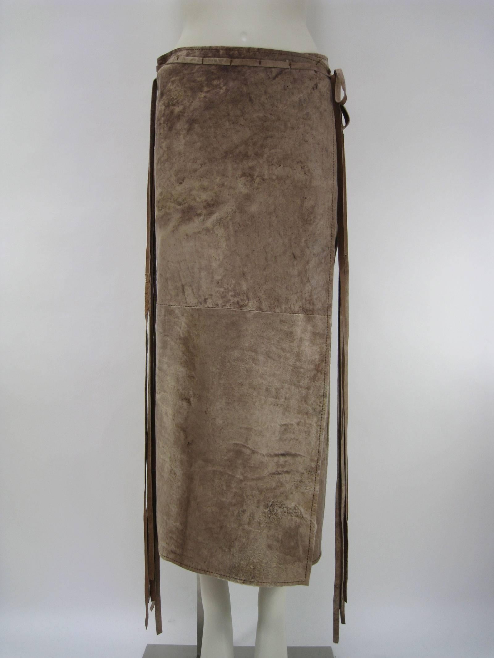 Unusual Ann Demeulemeester wrap skirt.
Very southwestern feeling in shades of tan with yellowish undertones.
Long mid calf length.
Distressed and weathered suede leather.
Pieced together to create very unique antiqued effect.
Sone pieces are