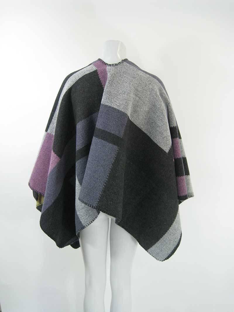 This Burberry poncho is a blend of wool and cashmere. 

This garment is made in Scotland, 85% wool and 15% cashmere.

This is in excellent, lightly-used condition.

The total length of the wrap is 54.5 inches. The back length, from the neck opening