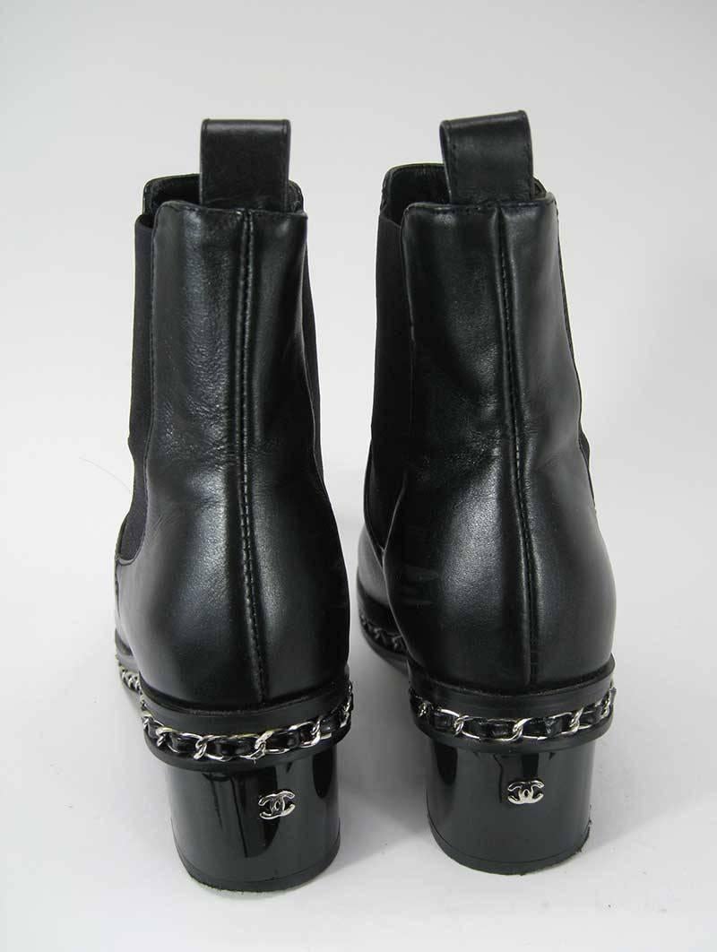 Chanel ankle boots in black leather with Chanel's iconic threaded chain encircling the boots and metal CC logo at the back of the heel.

These are in excellent pre-owned condition overall. The leather is soft and supple and the heels and soles are