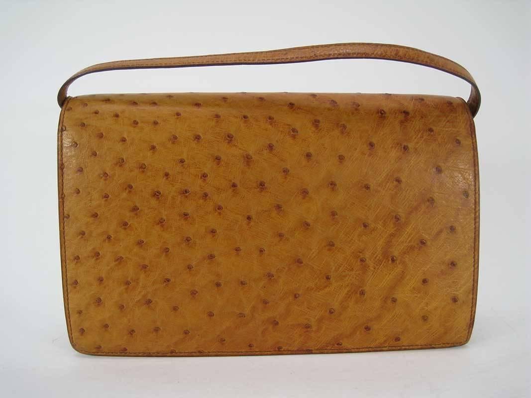 A vintage Hermes bag in ostrich. Very rare in this material and style.

The color is a tan/caramel.

The bag is in good vintage condition. This is a used, vintage bag that shows signs of wear.

Tan ostrich leather exterior trimmed with gold