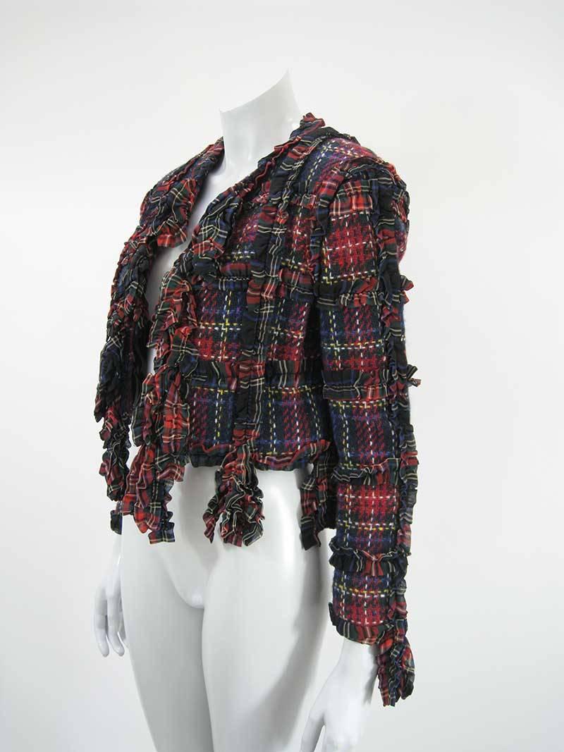 Veste en laine écossaise à franges de Moschino. La veste est étiquetée A/I (automne/hiver) 93/94.

Écossais rouge et violet.

Laine. Rayon Doublé.

Pas d'étiquette de taille.

Ce produit est en excellent état, sans trous, taches ou