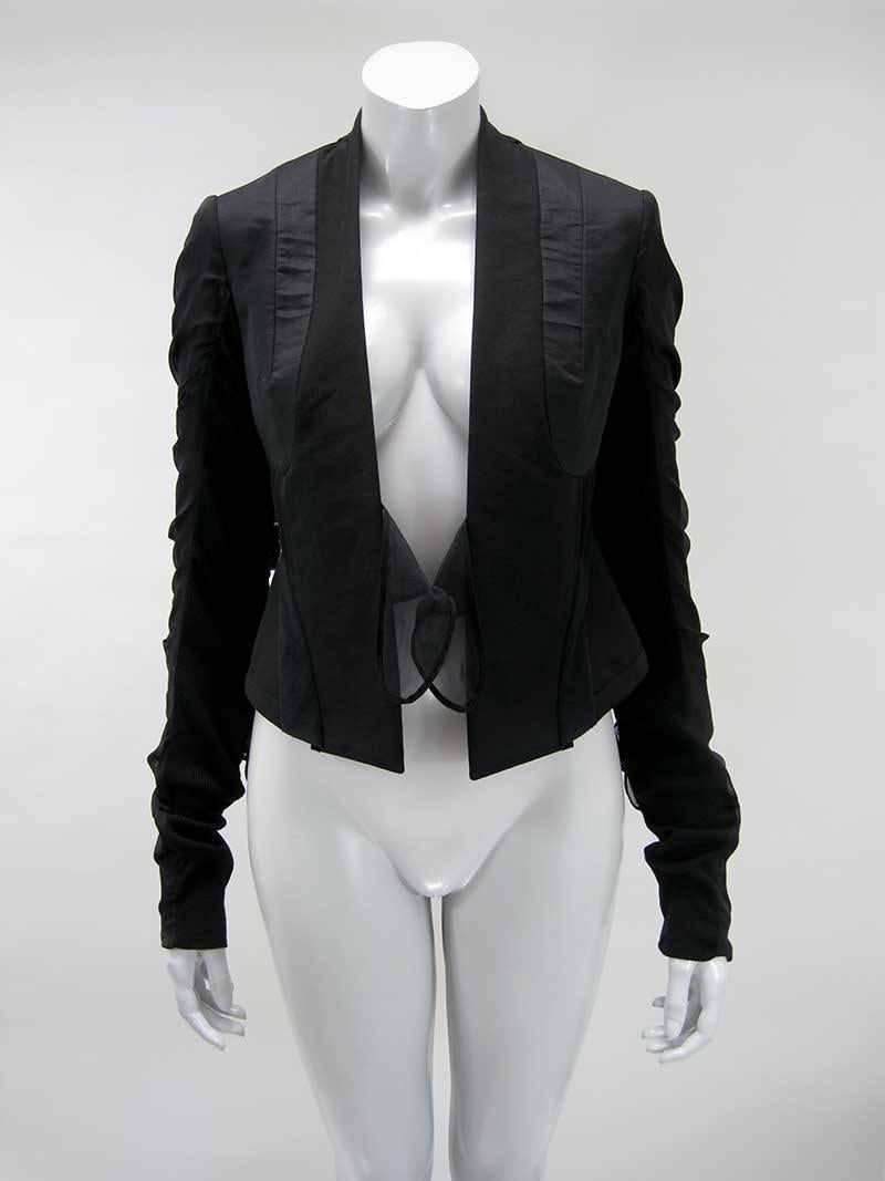Black cropped avant garde Rick Owens jacket.

Detailed constructed with panels, pin tucking and tie embellishments.

Fitted cropped shape.

Extra long exaggerated sleeve.

Stretch ribbed knit underarm panel with silk ties along outer