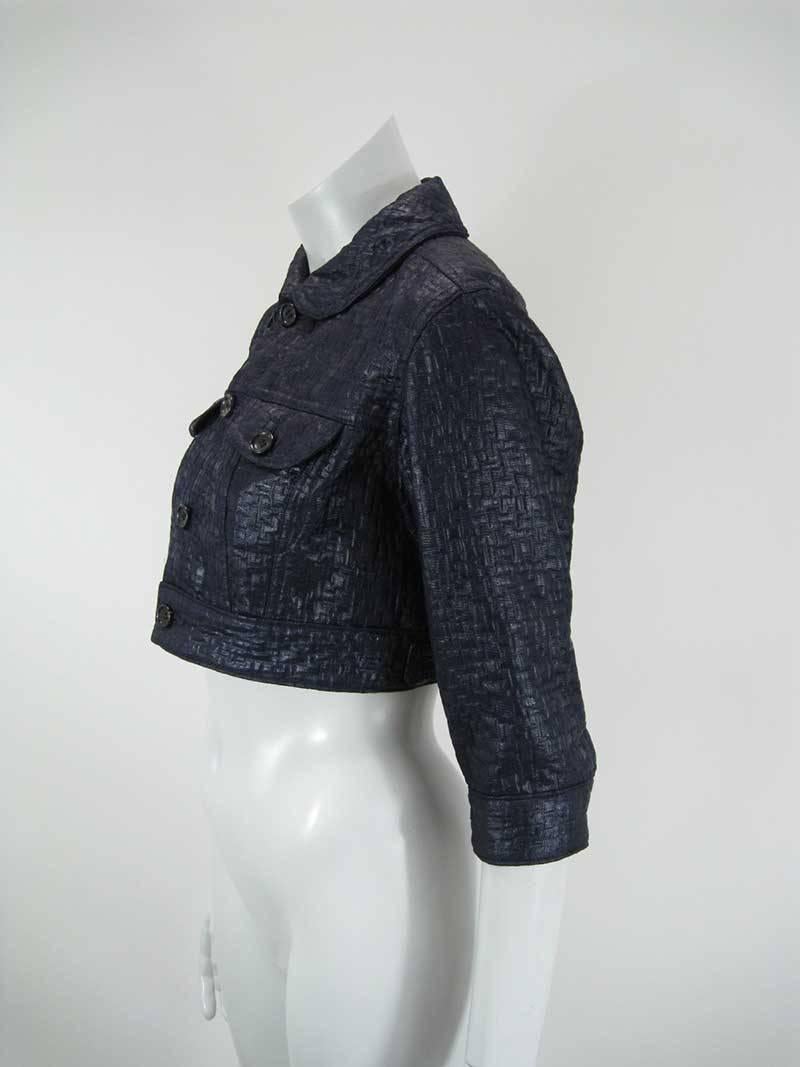 Deep navy blue Comme des Garcons cropped jacket.

Basket weave texture with sheen to fabric.

Cropped to hit at waist.

Button closure.

Front chest pockets.

Adjustable side tab closures.

Elbow sleeve with closure.

Tagged a size Medium.

Fabric