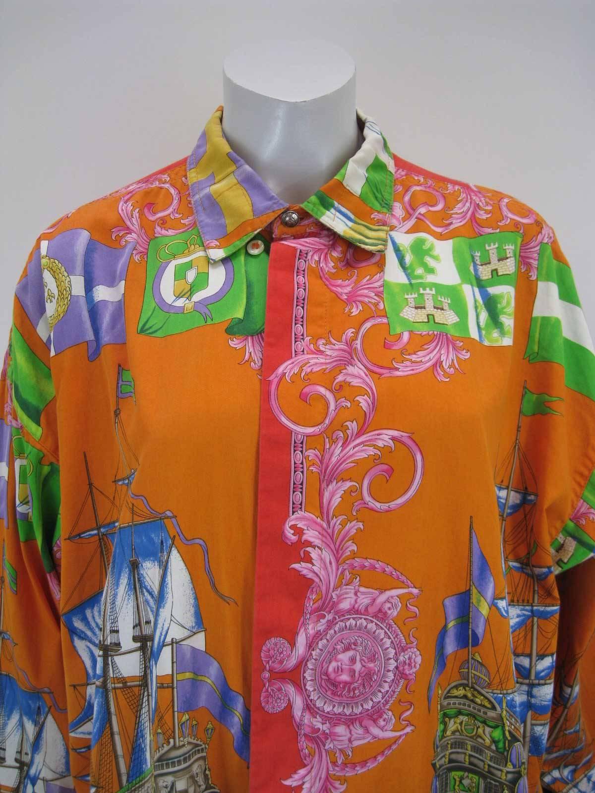 Striking Gianni Versace button down shirt.

Decorative print of sailboats, sun faces, flags and more.

Vibrant hues of orange, yellow, red, blue, green, pink and more.

Button down collar.

Hidden button placket.

Fabric is cotton.

Button