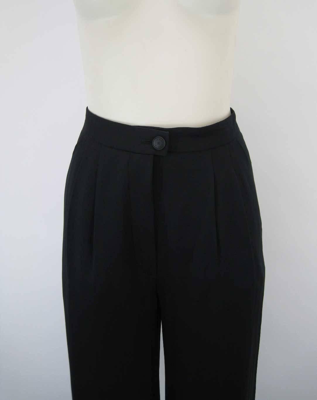Elegant Chanel black silk cuffed pant.

Flattering cropped length.

Inverted double pleated waist.

Chanel embossed button closure with zipper.

Loose, wider leg with cuff.

Side pockets.

Fabric is silk.

No size tag.

This item is in excellent