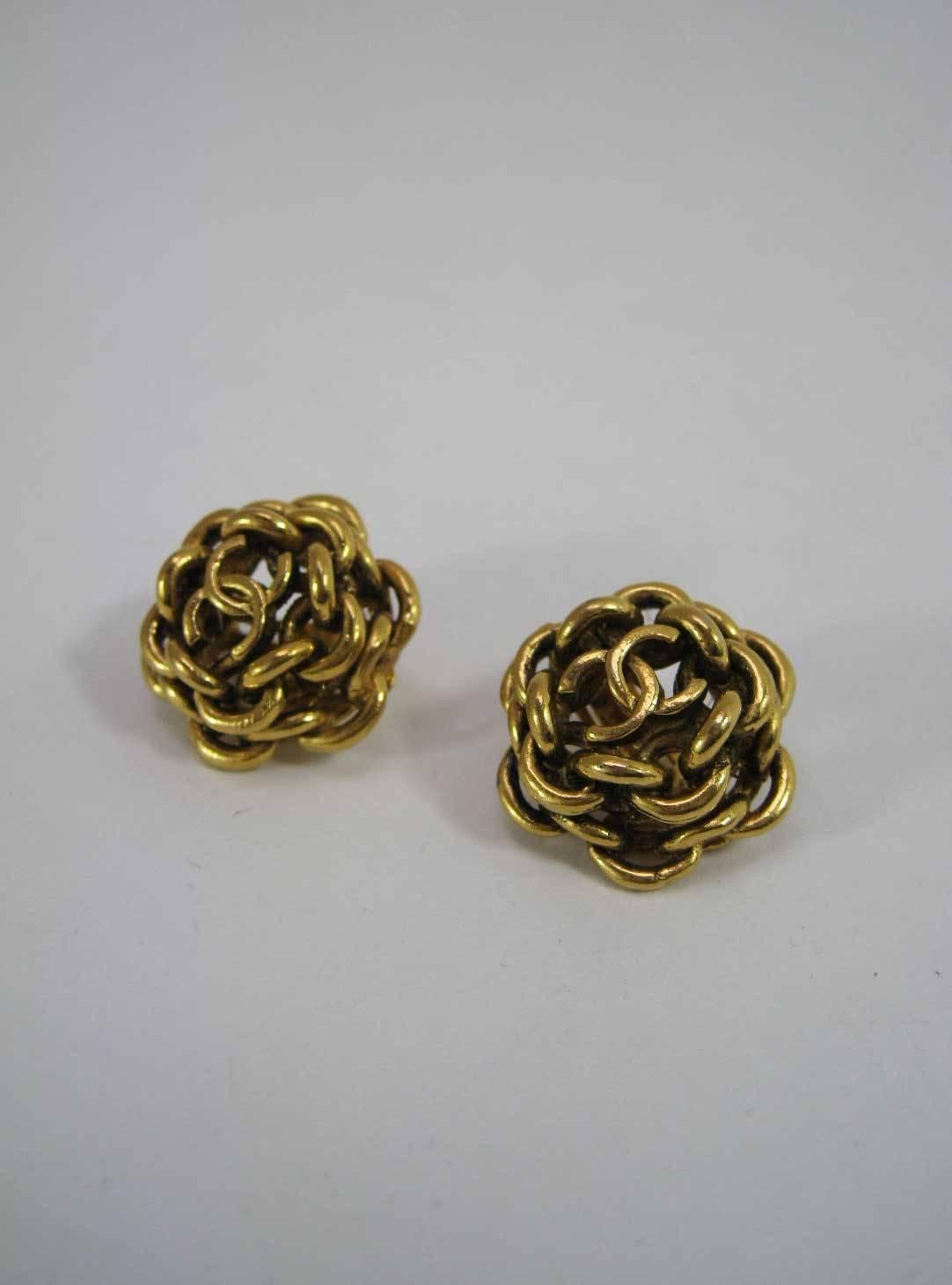 1980's Chanel gold tone interlocking CC earrings.

Round rows of interlocking chain with CC on top.

Clip-on style. 

Stamped 222 Chanel on back.

This item is in excellent pre-owned vintage condition with minimal wear to metal.

MEASUREMENTS:
1