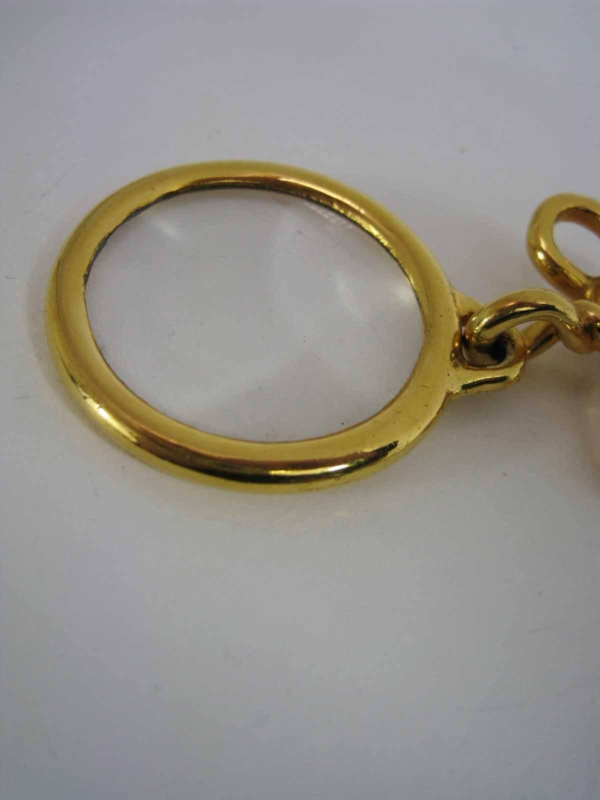Chanel chain necklace with large magnifying glass loupe pendant.

High gloss gold-tone gilt metal with considerable weight.

Long interlinked chain.

Large round glass magnifier with small CC on pendant with Chanel stamp on back.

Stamped 93 P