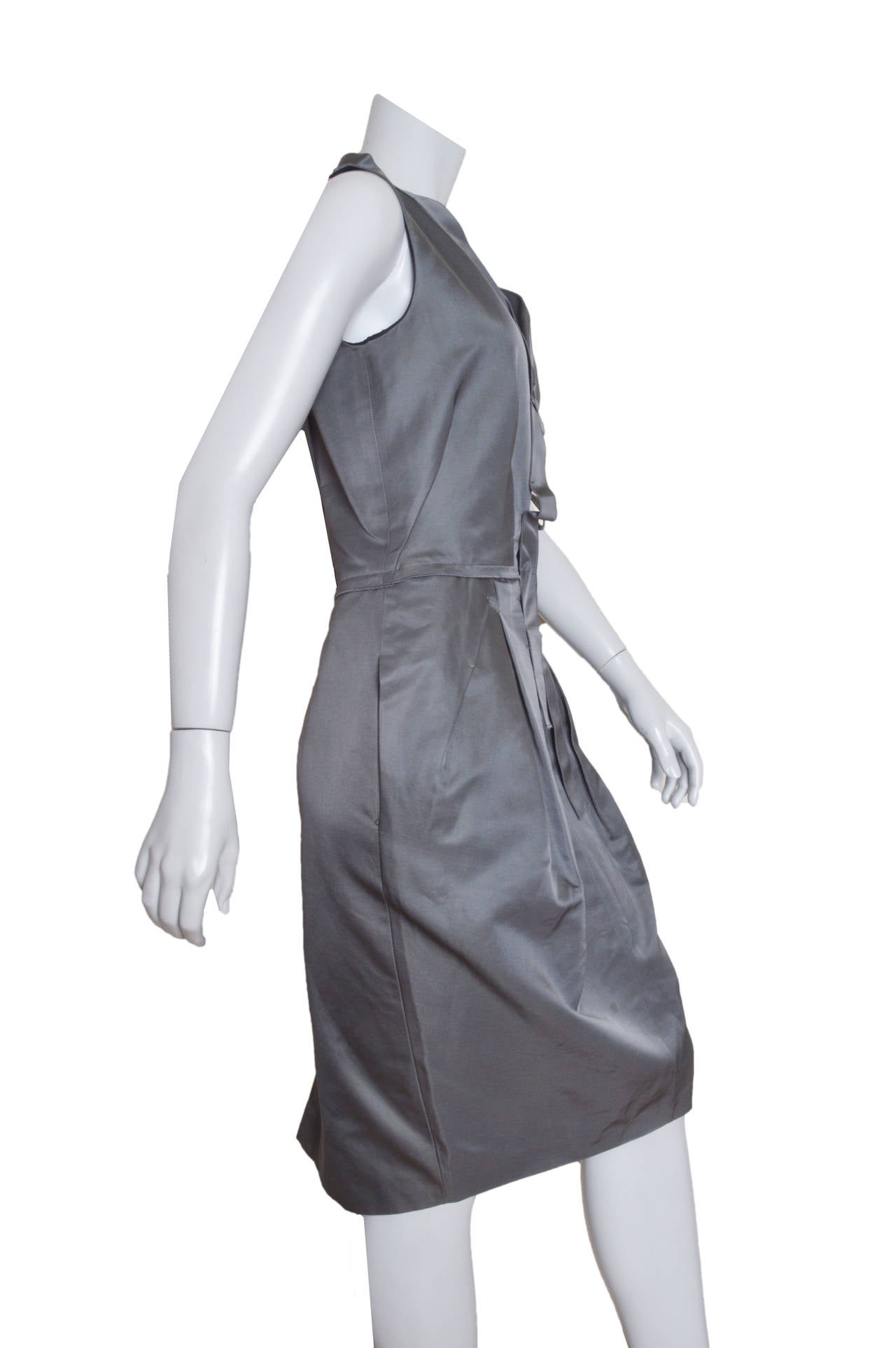 Structural Gianfranco Ferre grey dress.
Luminous sateen fabric.
Wide ribbon folded collar.
Pintuck pleated bodice with tacking. 
Fitted through waist.
Exaggerated pintucking and pleating on skirt.
Side pockets, kick pleat a back hem.
Exposed