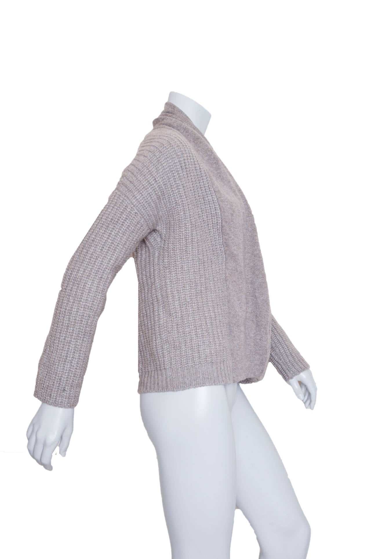 Sumptuous Brunello Cucinelli cable knit cashmere sweater.
Gray with metallic gold speckles.
Exaggerated shoulder, plunging crossover draped neckline.
Secured with button closure.
Tagged a US medium.