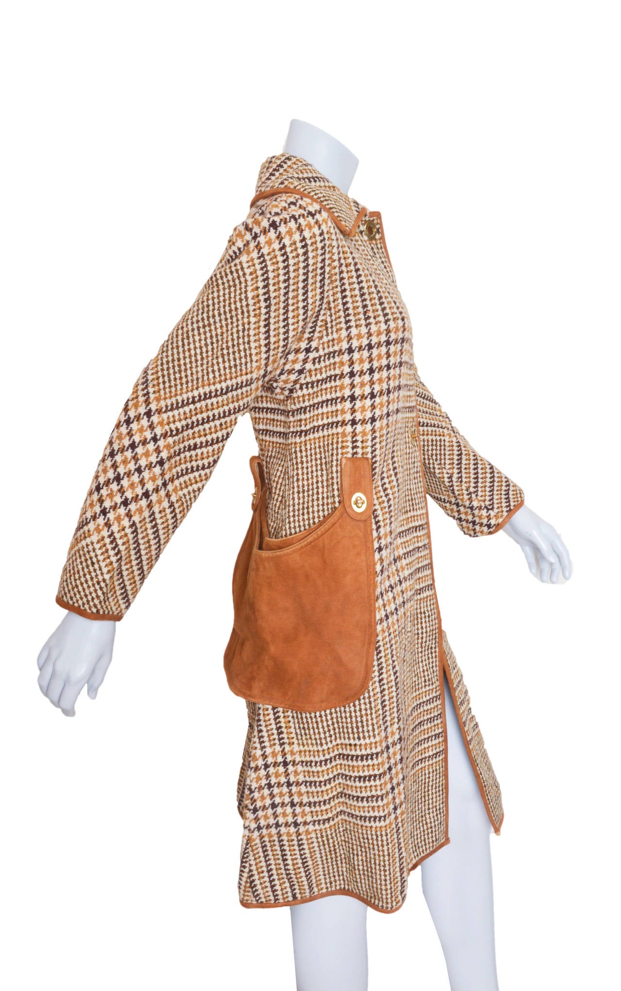 Classic Bonnie Cashin wool tweed coat.
Trimmed in tan suede leather.
Underside of collar is suede.
Brass grommeted button holes with twist toggle closures
Detachable suede bucket pockets.
Unlined.