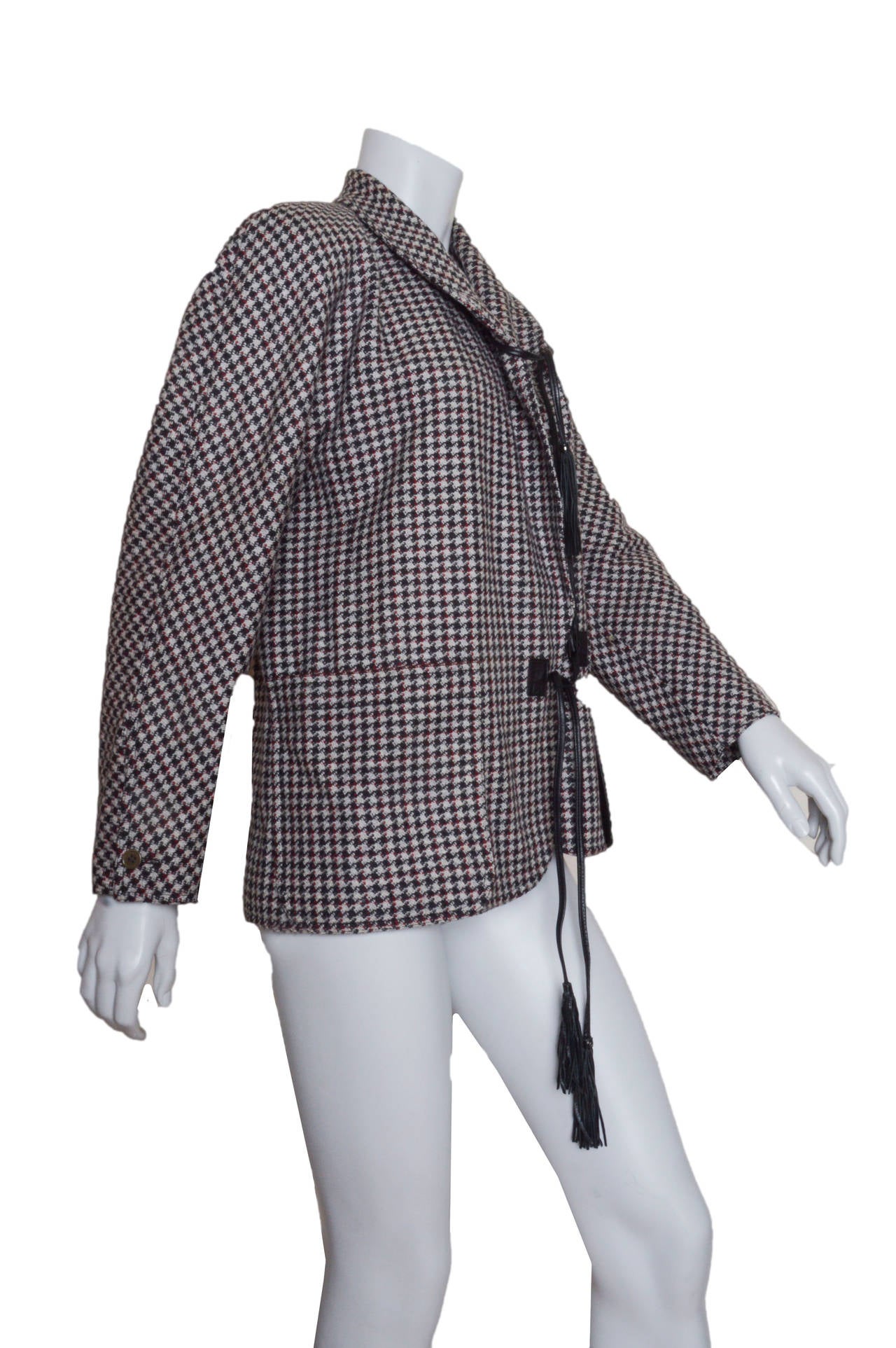 Vintage Gucci tweed jacket.
Back, grey, red and off white.
Boxy shape with black leather cord closures with tassels.
Slit chest pocket and two front patch pockets.
Lined.
Tagged a size 38.