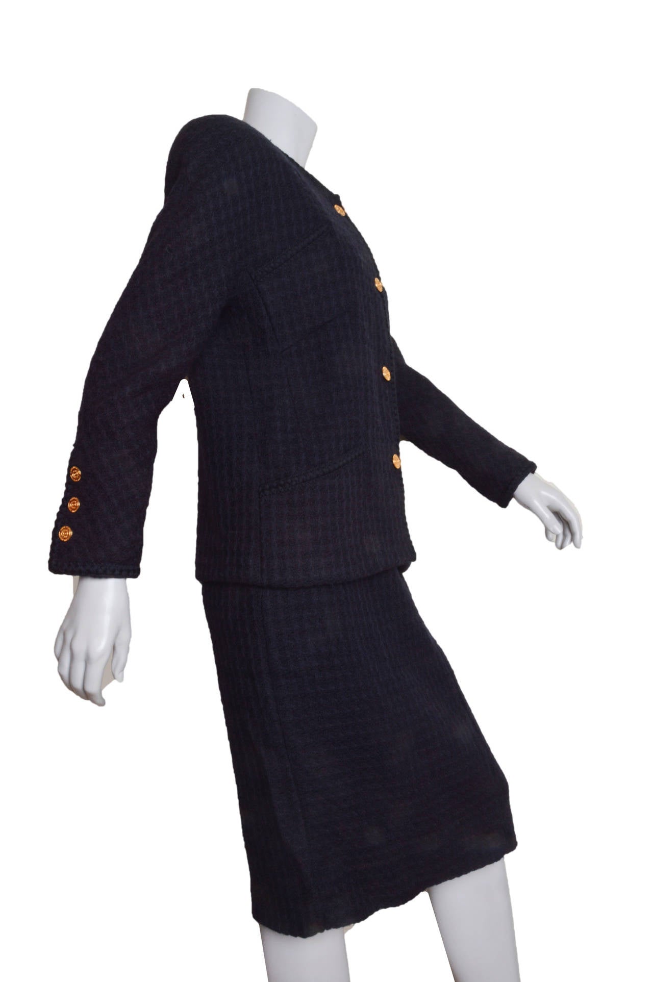 Understated and elegant vintage Chanel Boutique dark navy blue suit.
Boucle with a subtle woven pattern.
Jacket features classic braided trim, four pockets and
gold embossed Chanel buttons.
Gold chain sewn inside waist hem.
Slightly fitted