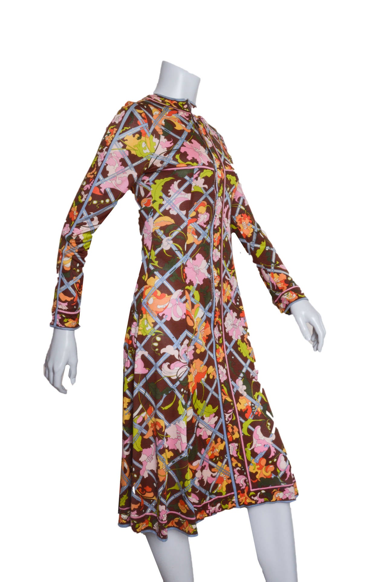 Superbe robe vintage Emilio Pucci à imprimé automnal.
Des fleurs qui se faufilent dans un treillis.
Jersey de soie en marron profond avec du rose, du bleu pâle, des oranges et des jaunes.
Col haut. 
Ajusté à la taille, il s'évase en une jupe