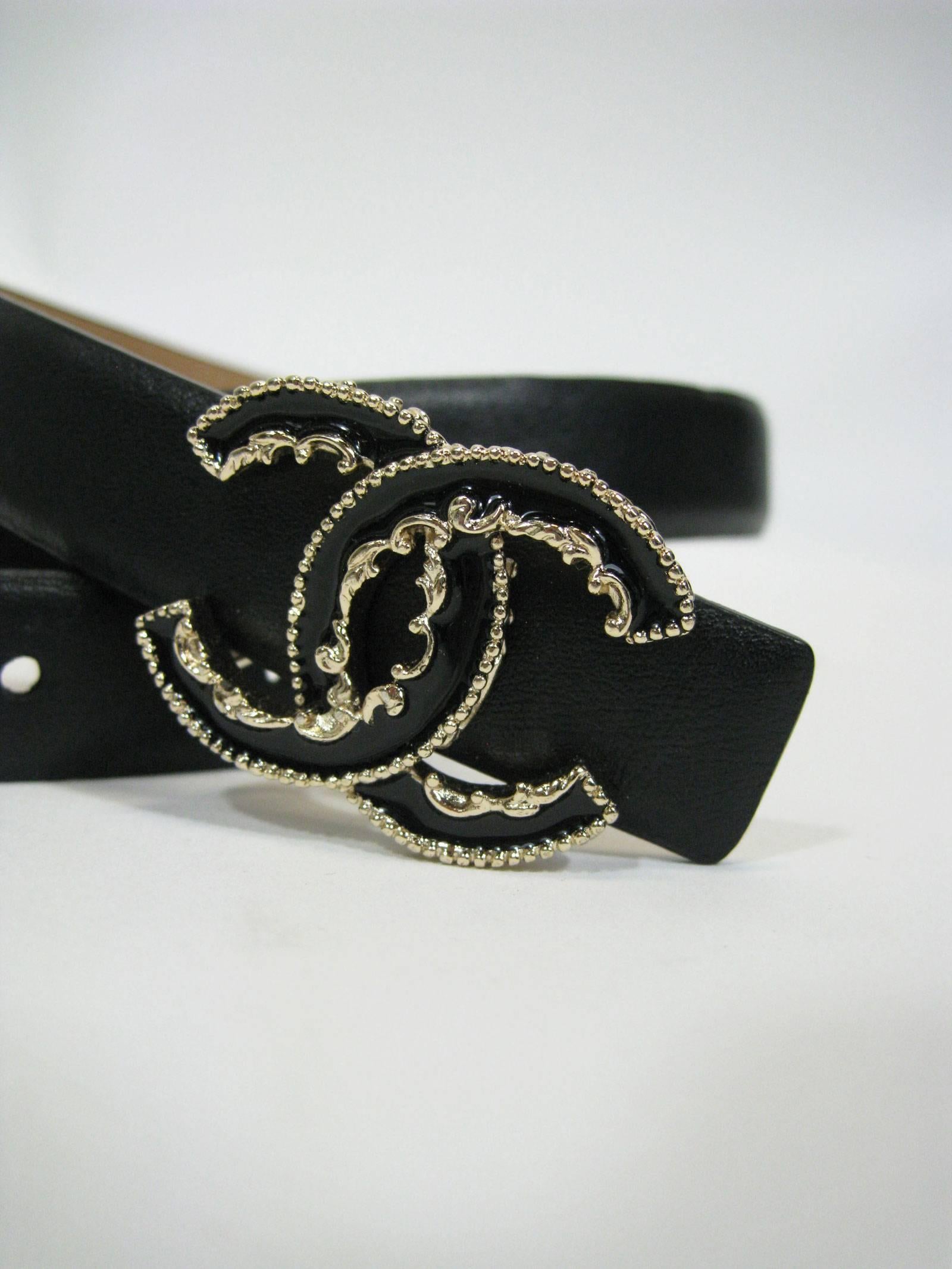 Schlichter:: eleganter:: schmaler:: schwarzer Gürtel von Chanel. 
Doppelte abnehmbare Cc-Schnalle. 
Cc-Logo ist schwarz umrandet dekorative goldene Wirbel und Punkte. 
Geschmeidiges Lammfell. 
Gekennzeichnet mit Größe 85/34. 

Breite: 1 3/4
