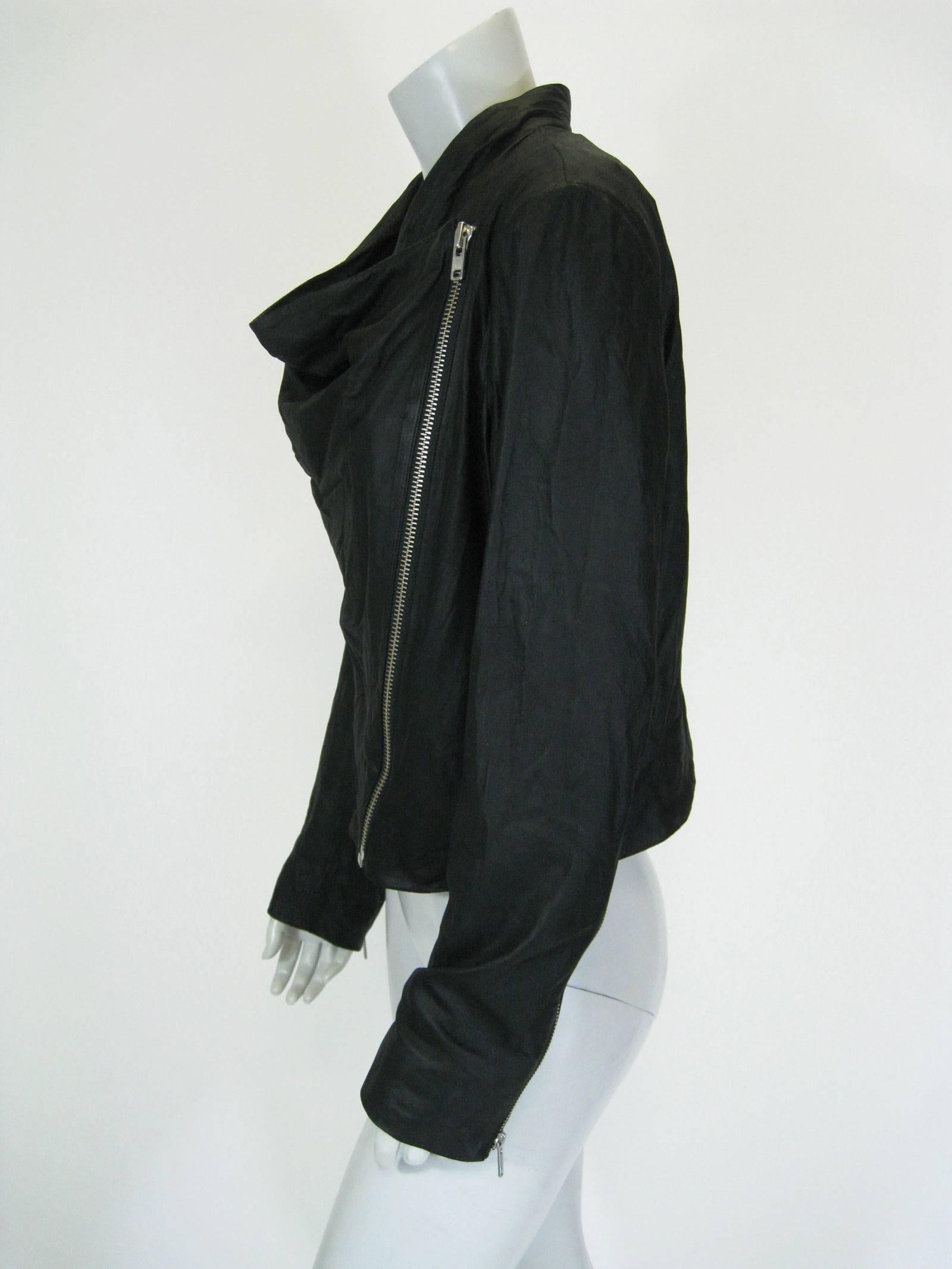 The modern biker jacket by Helmut Lang.
Soft supple black lambskin.
New with tags.
Loose, cowl neck.
Asymmetrical side zipper with snap closure.
Side pockets.
Long sleeve with zippers on wrists.
Lined in cotton.
Tagged a size large.