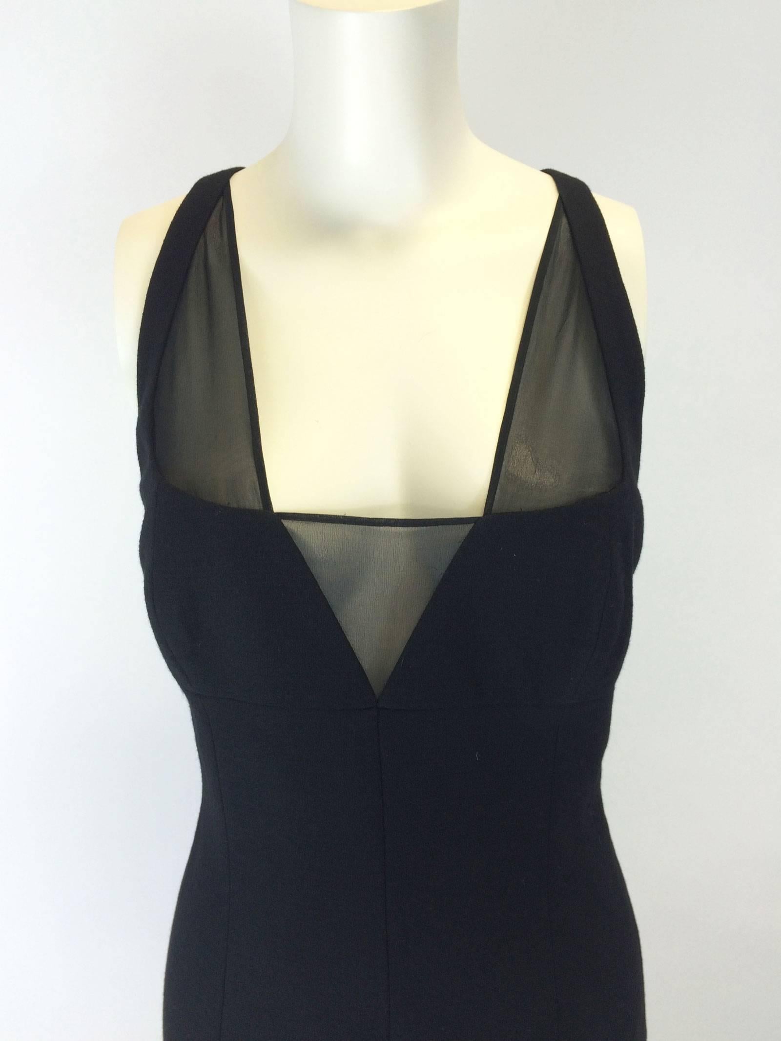 Sexy fitted black Versace dress.
Detailed seaming on bust, empire waist.
Deep neckline with sheer inserts.
Criss cross back.
Stretchy, heavier weight elastane and wool blend.
Back kick pleat.
Back zipper.
Lined.
Tagged a size 42.