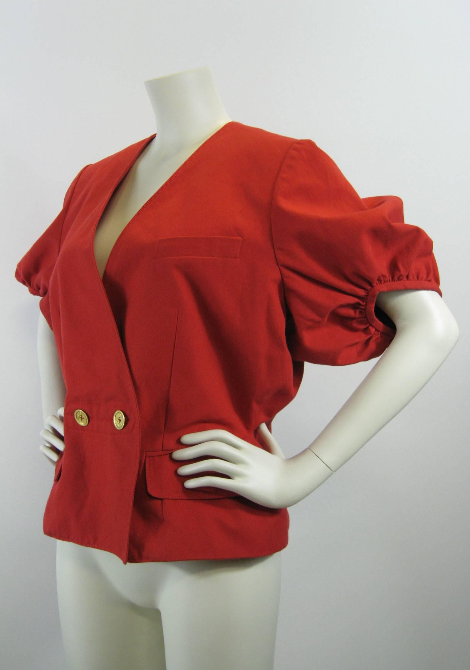Bright red Yves Saint Laurent jacket.
Slightly structured cotton poplin.
Short puffed sleeves.
Double breasted with YSL imprinted buttons with anchors.
Darted with fitted and flare at hips.
Faux chest pocket.
Two front hip patch